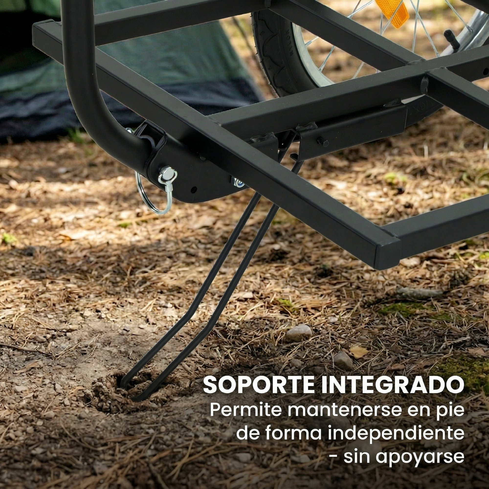Remolque de bicicleta negro con patas de apoyo en el suelo, tienda atrás.