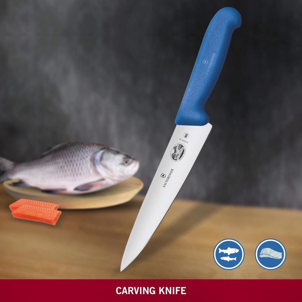 Mavi saplı bir Victorinox bıçağı, bir balık ve somon parçalarının yanında duruyor.