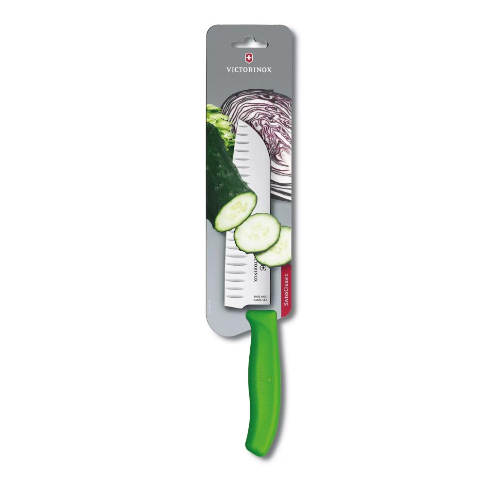 Yeşil saplı Victorinox sebze bıçağı, salatalık ve kırmızı lahana parçalarının yanında blister pakette.