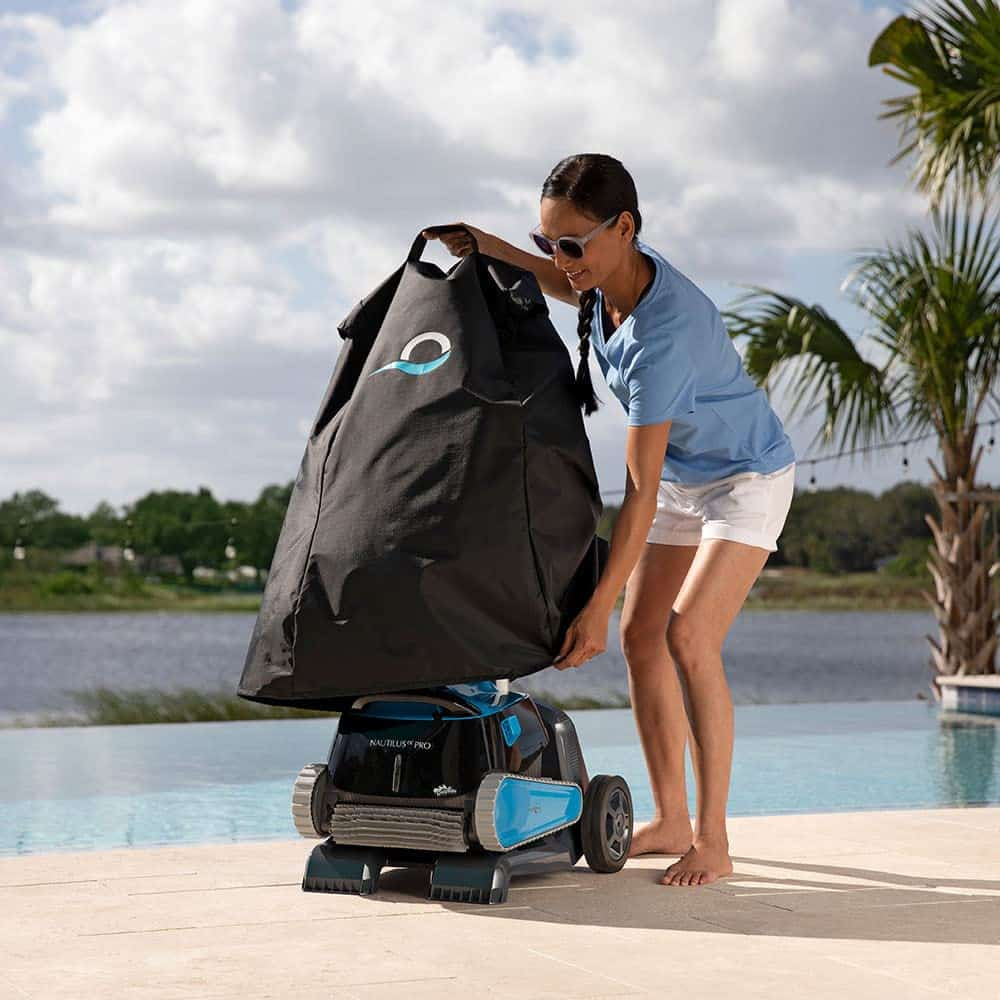 Mujer cubre robot de piscina con funda negra junto a la piscina.