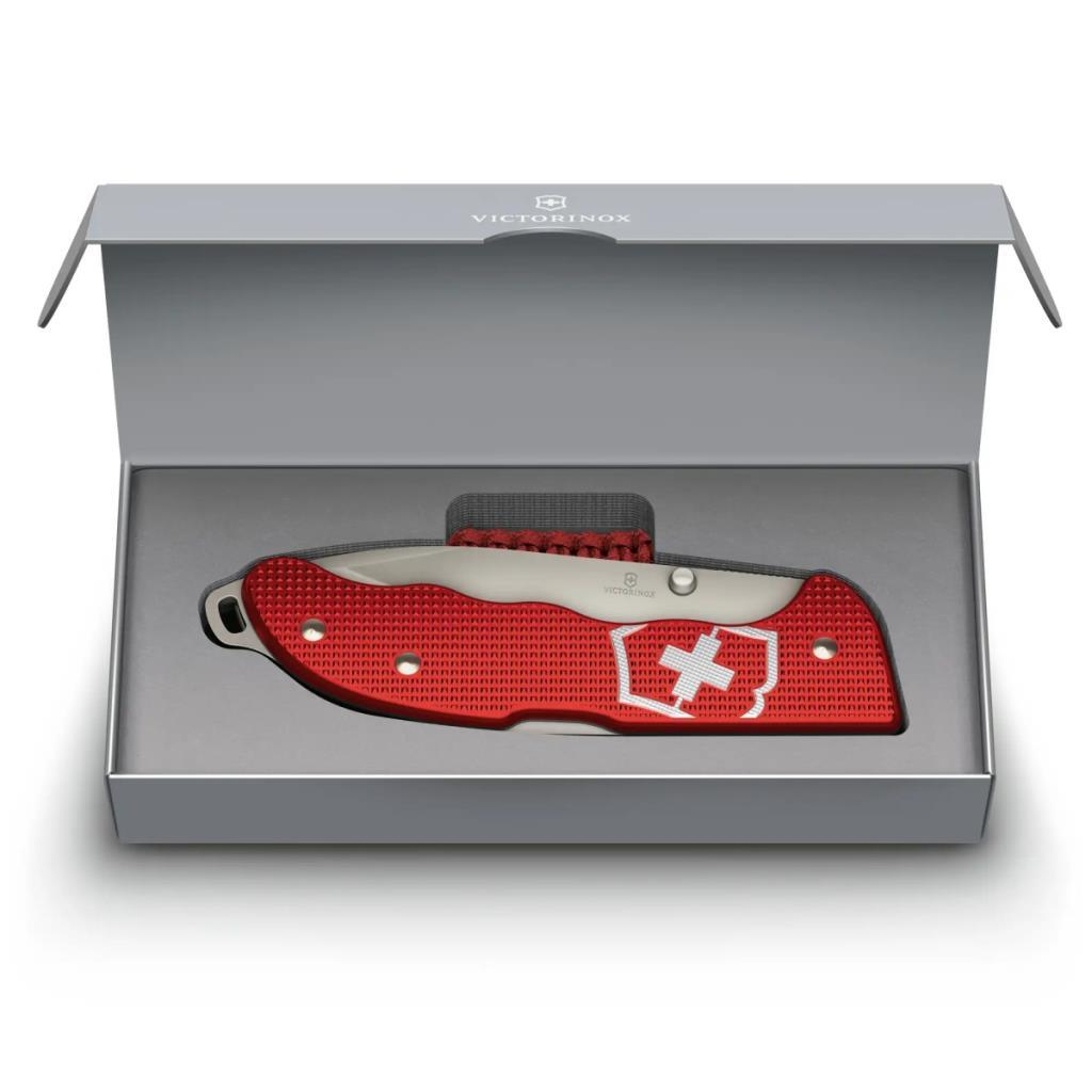 Kırmızı Victorinox cep çakısı, üzerinde İsviçre haçı logosu, kutuda.