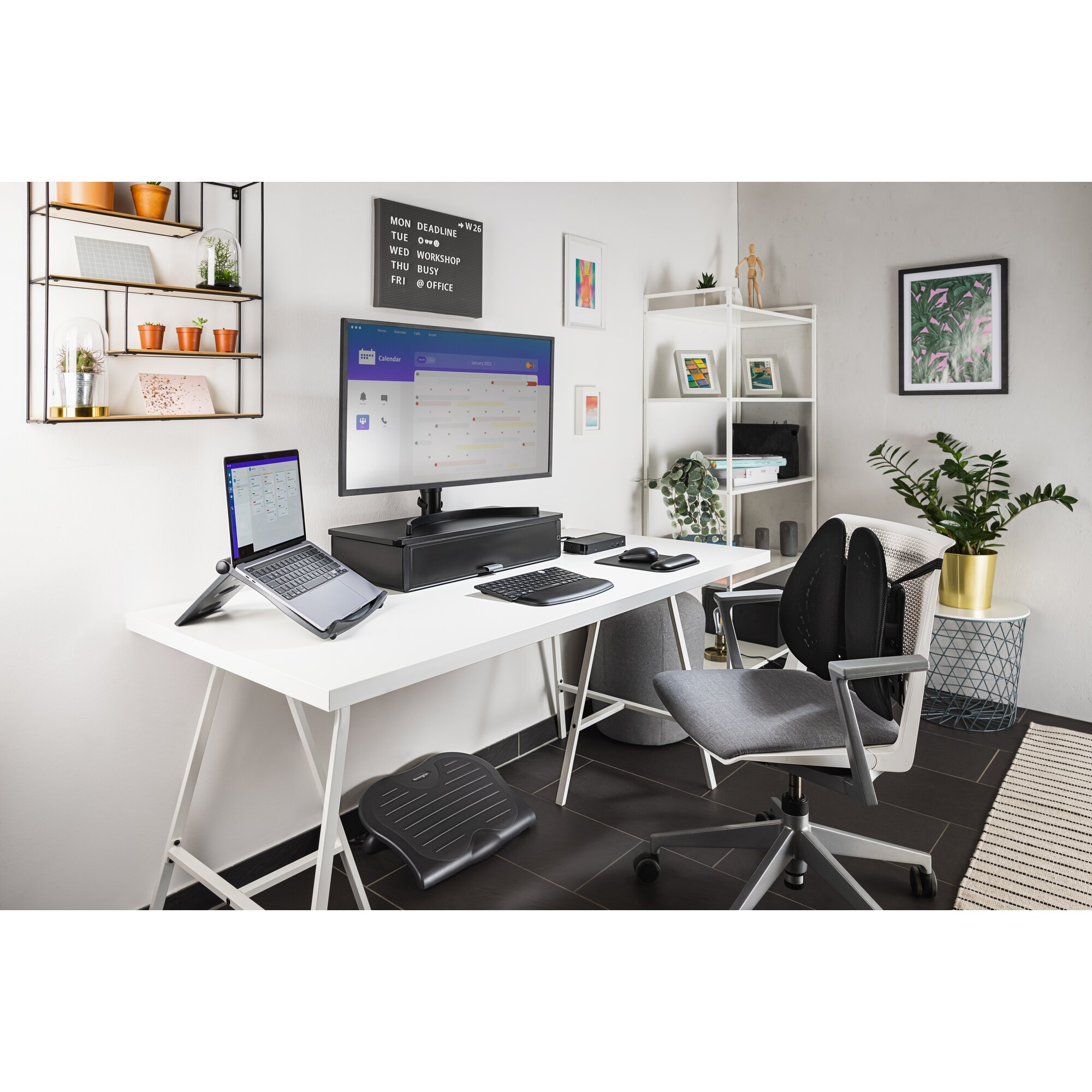 A white desk with a laptop, monitor, keyboard, mouse, and footrest.
