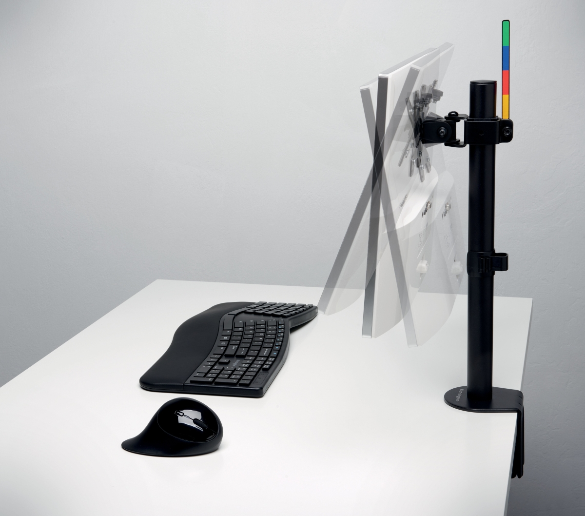 Ergonomisch toetsenbord en muis op een bureau met een monitorarm.