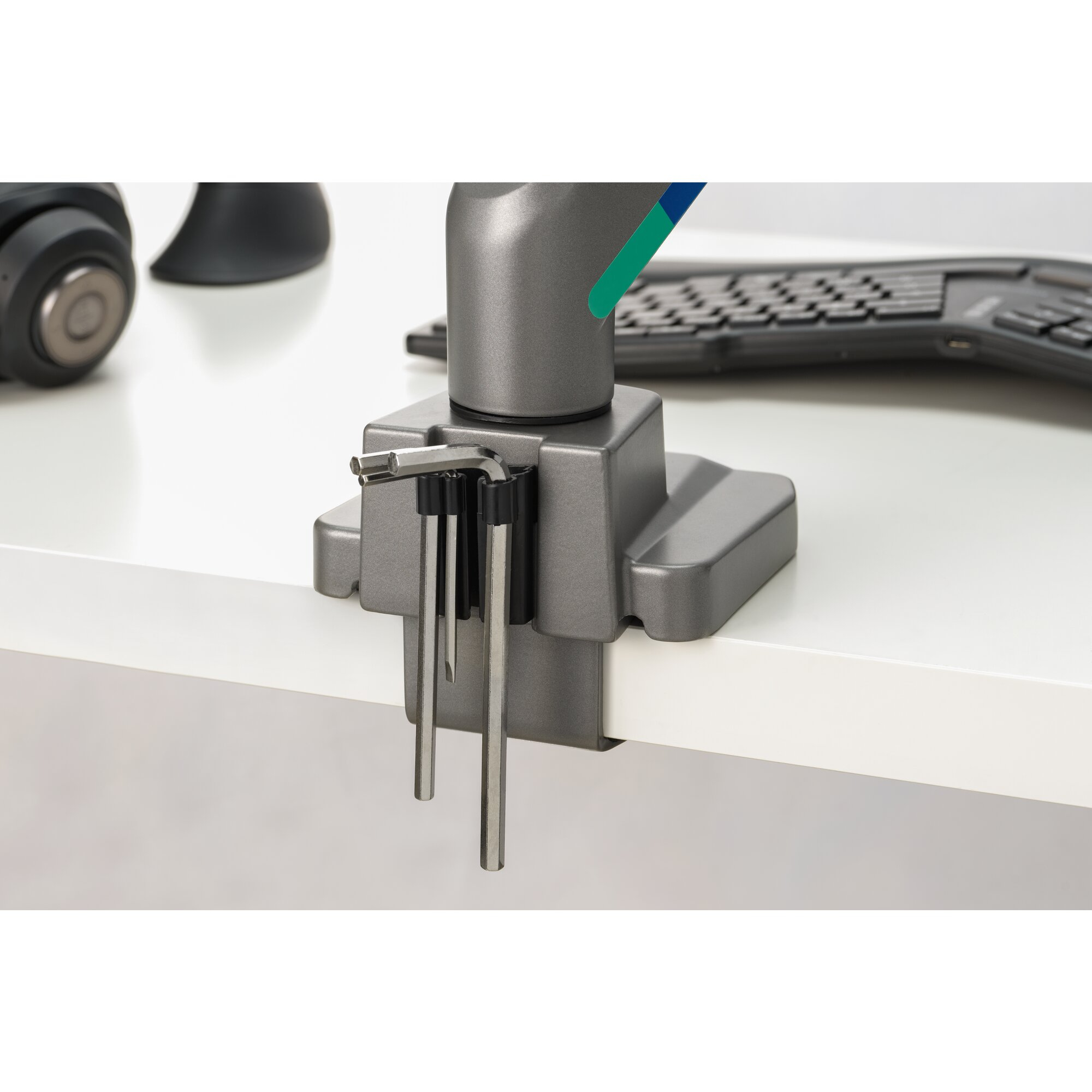 Gray desk clamp with Allen wrenches and keyboard in the background.