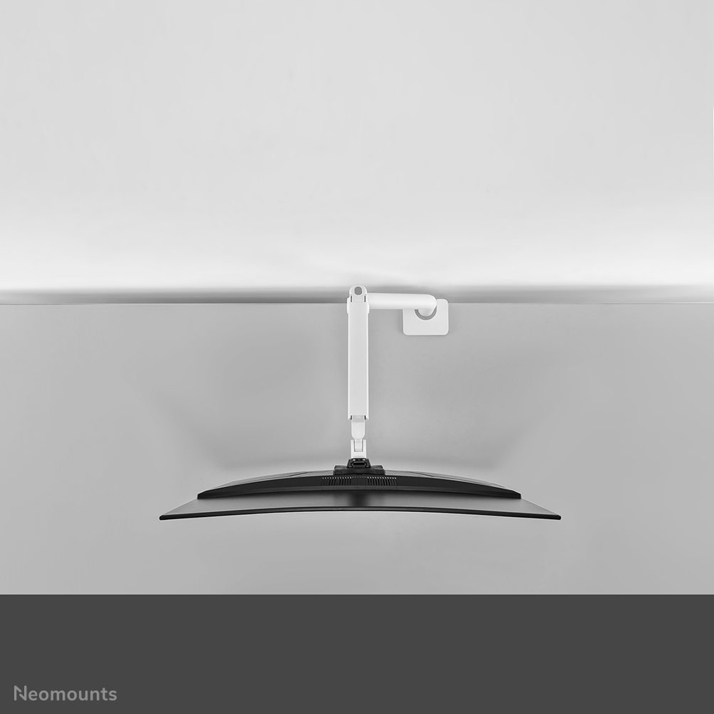 A white monitor arm is attached to the wall, holding a curved black monitor.