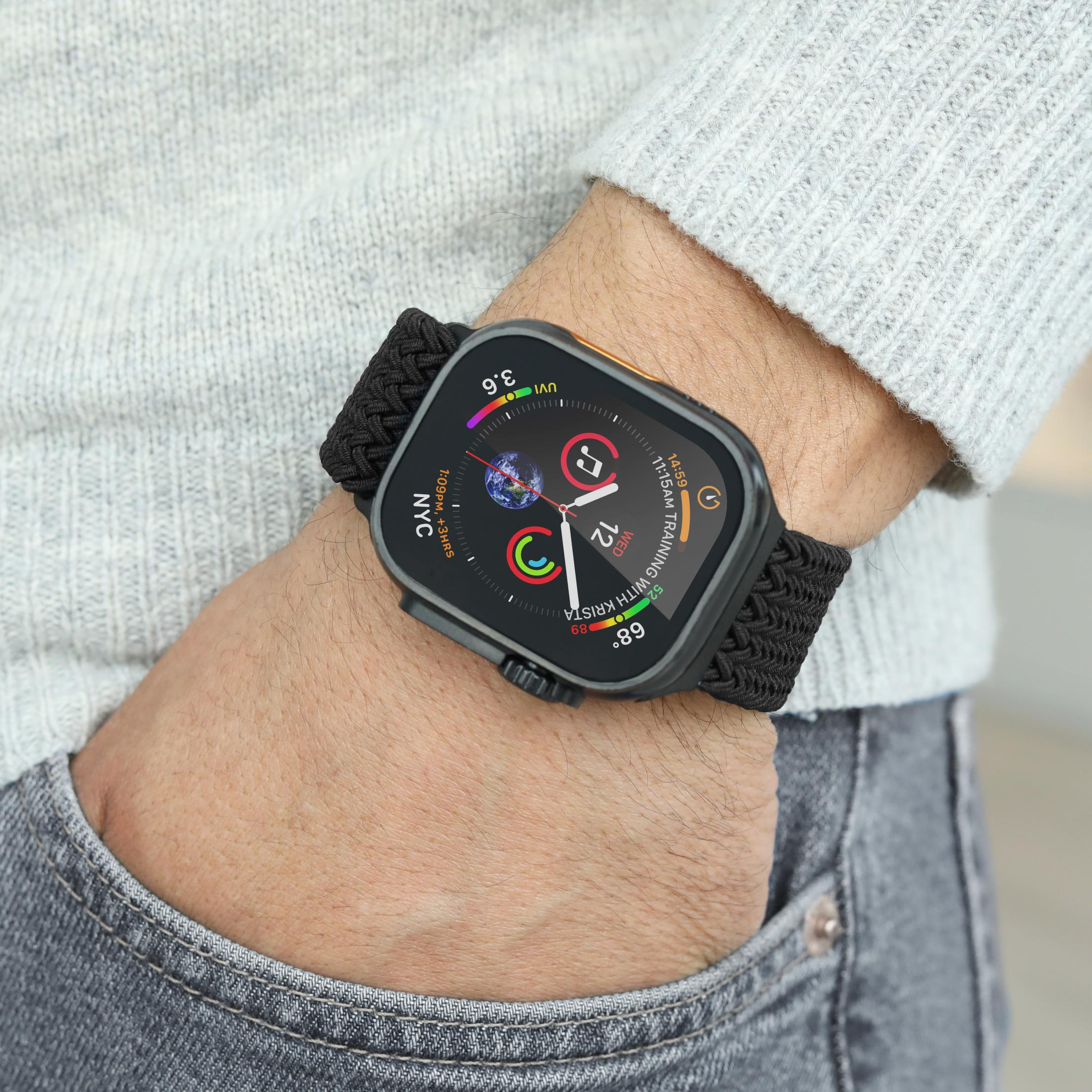 Haut en tricot gris, jean et une montre connectée au poignet.