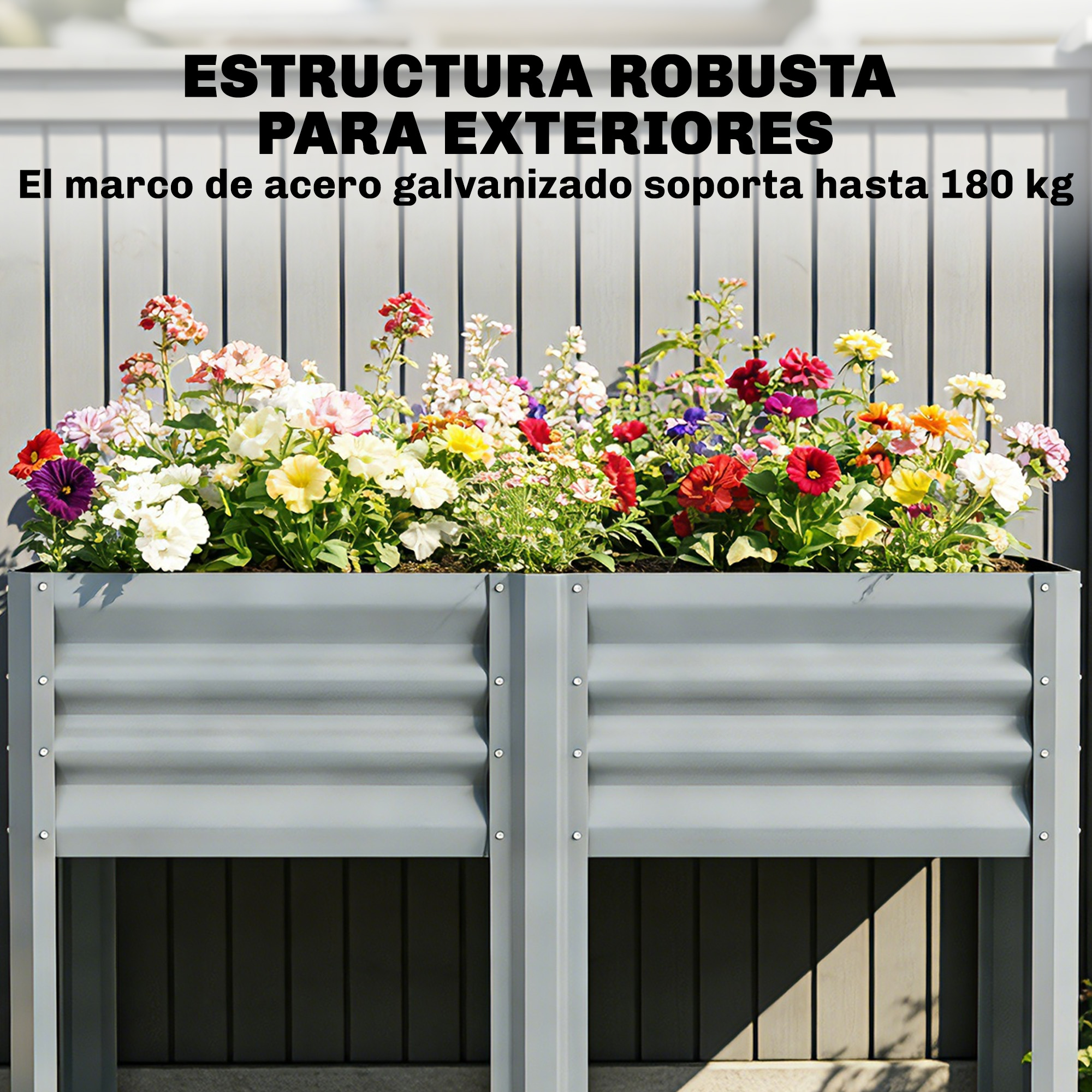 Banco de jardín elevado gris con flores coloridas. Marco de acero contra pared.