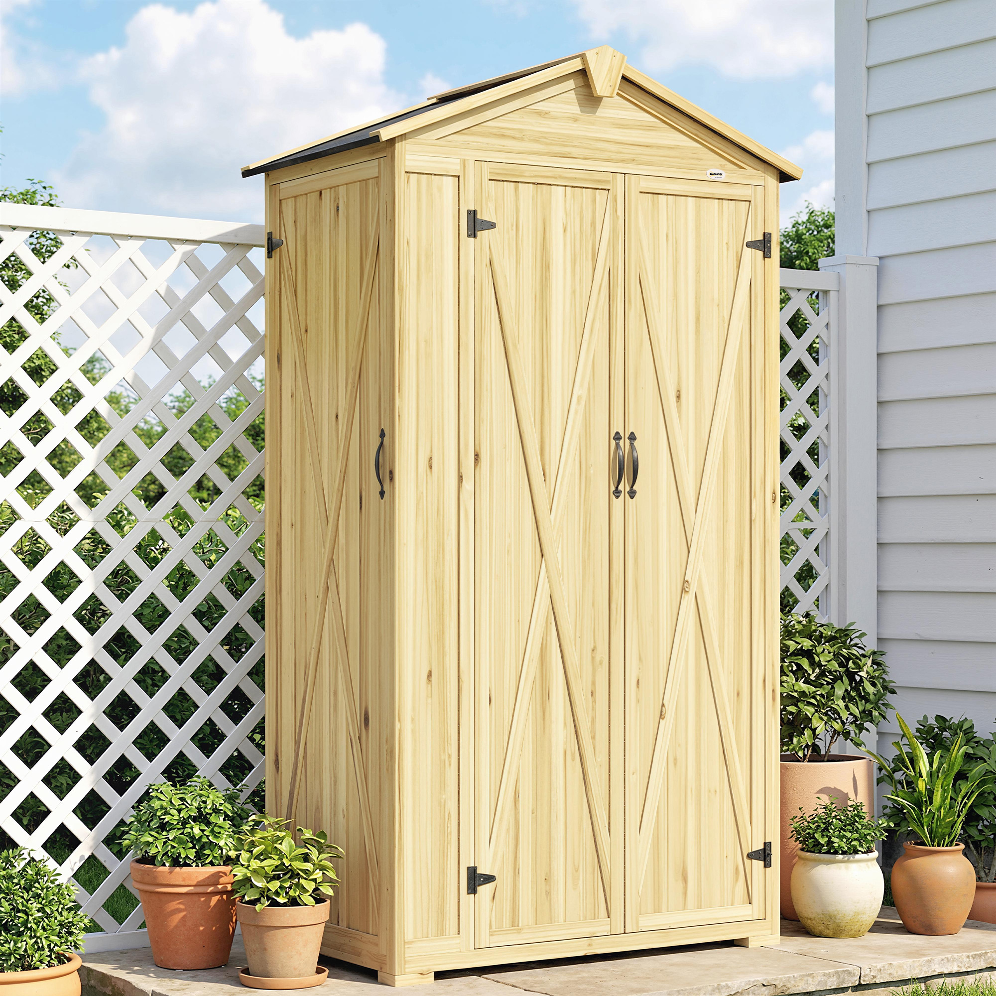 Cobertizo de madera con puertas dobles, valla de celosía blanca, plantas en maceta y cielo nublado.