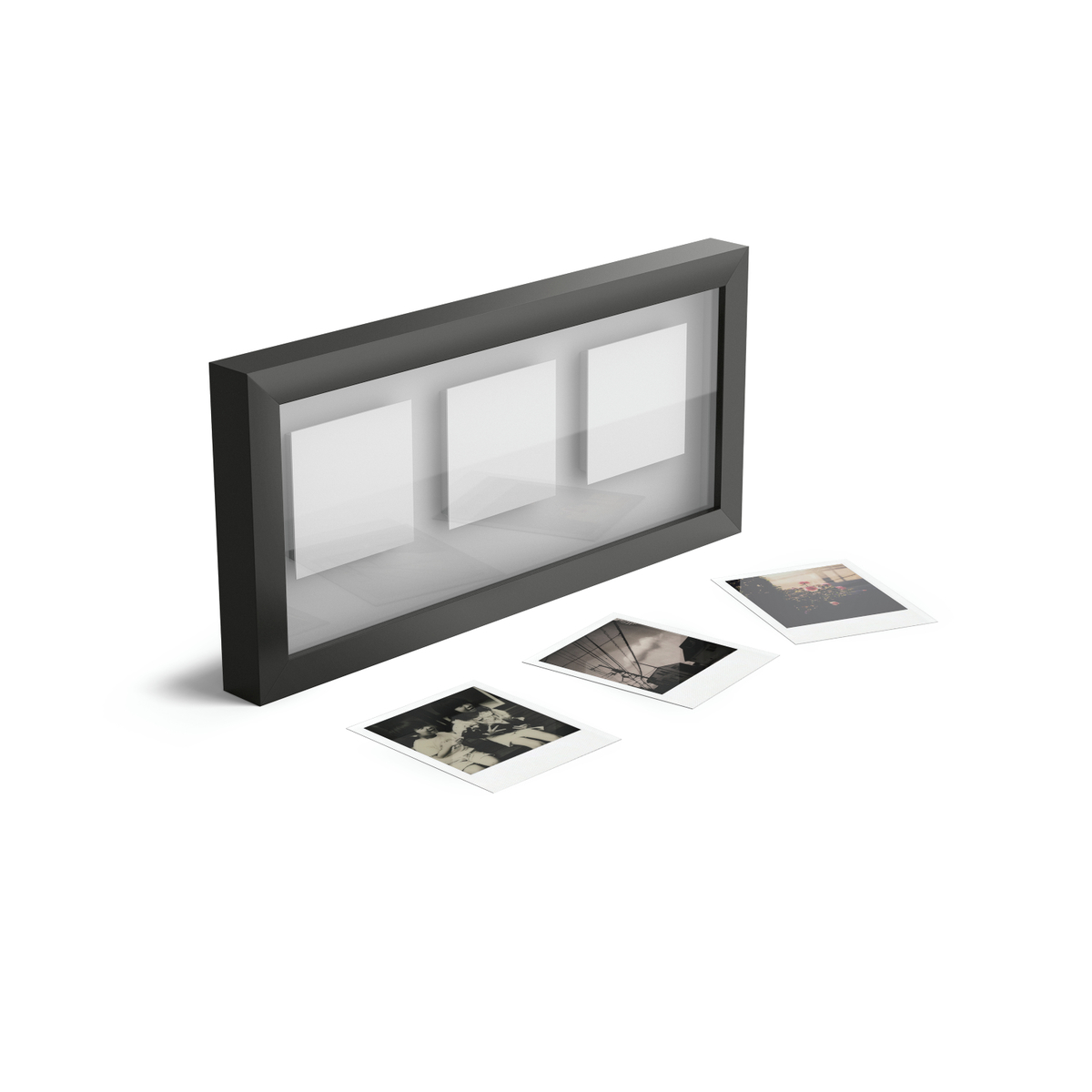 Ein schwarzer Fotorahmen für drei Bilder mit drei losen Sofortbildern davor.
