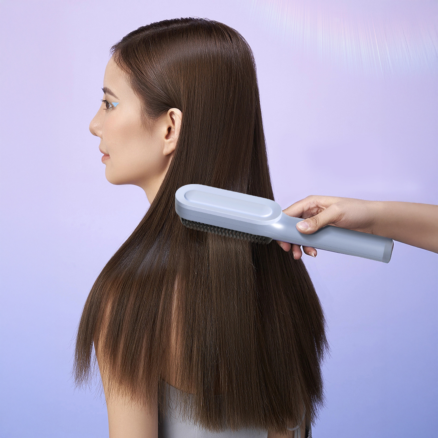 Una donna con lunghi capelli castani spazzolati da una spazzola grigia.