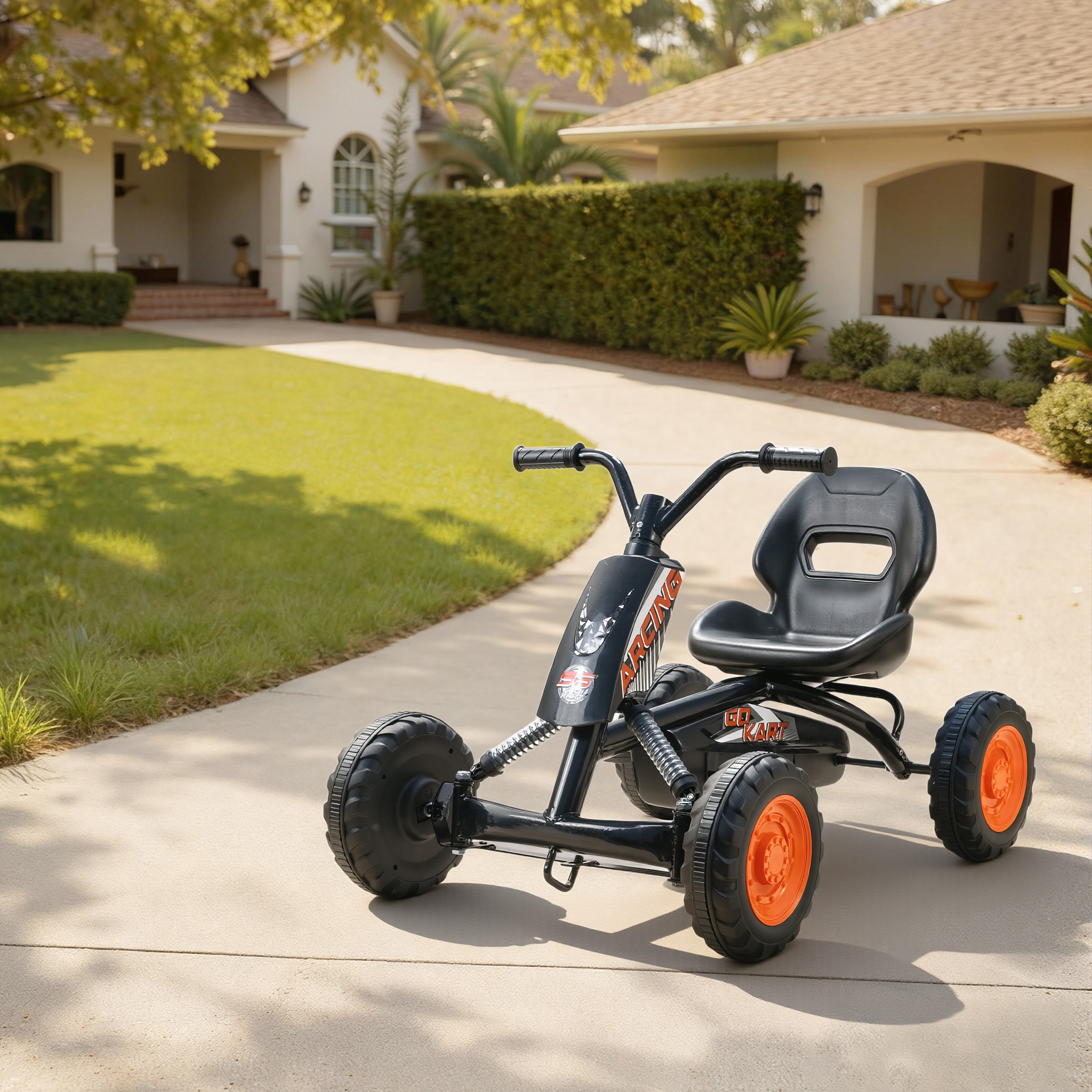 Un go-kart negro con ruedas naranjas está en una entrada de coche frente a una casa.