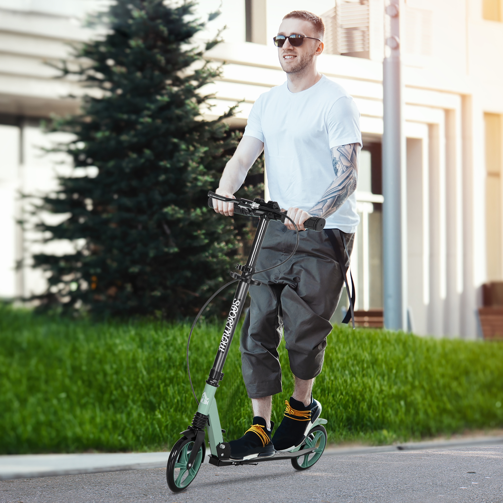 Un hombre con gafas de sol monta un patinete por un camino pavimentado.
