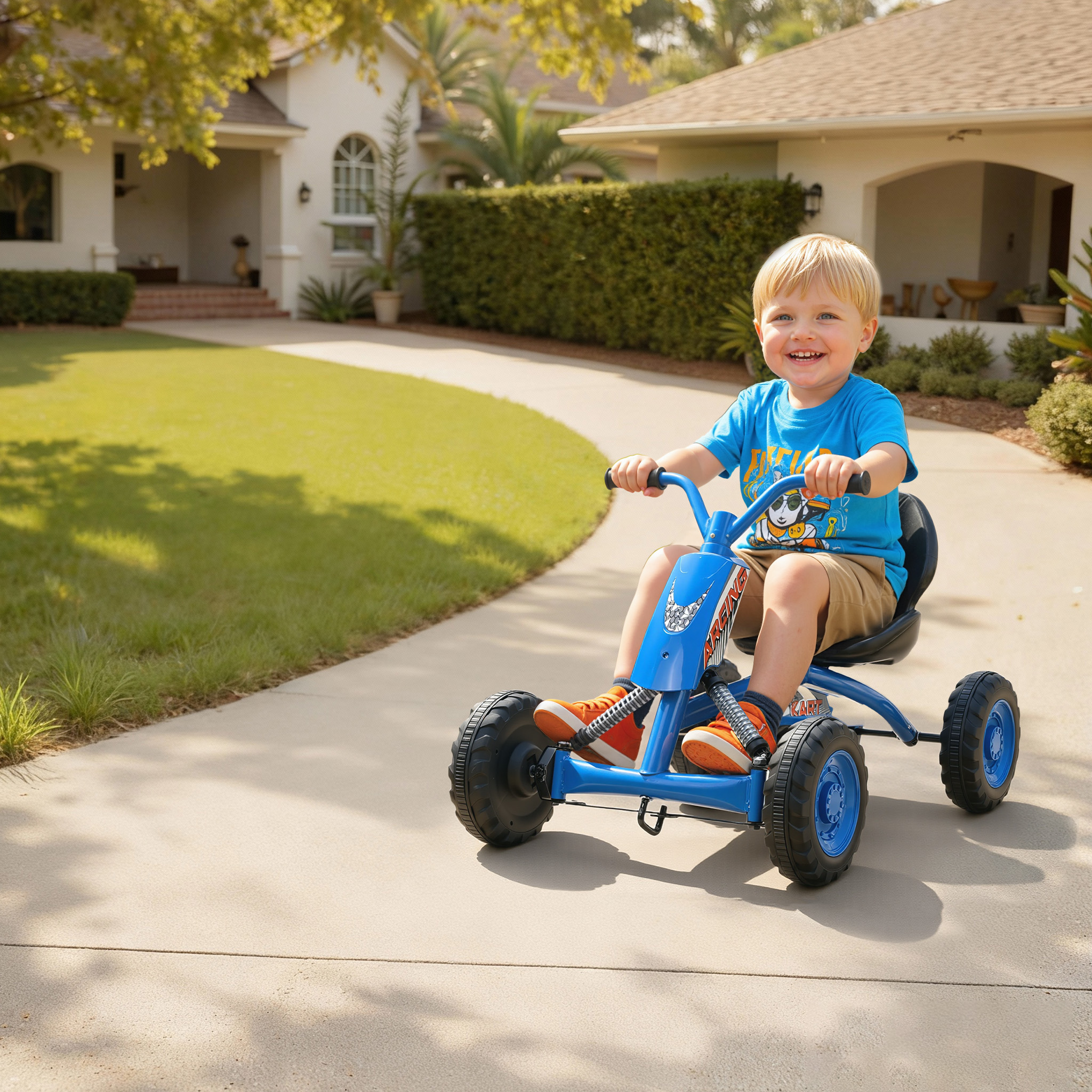 Un niño sonriente monta un go-kart azul en un camino de entrada pavimentado frente a una casa.