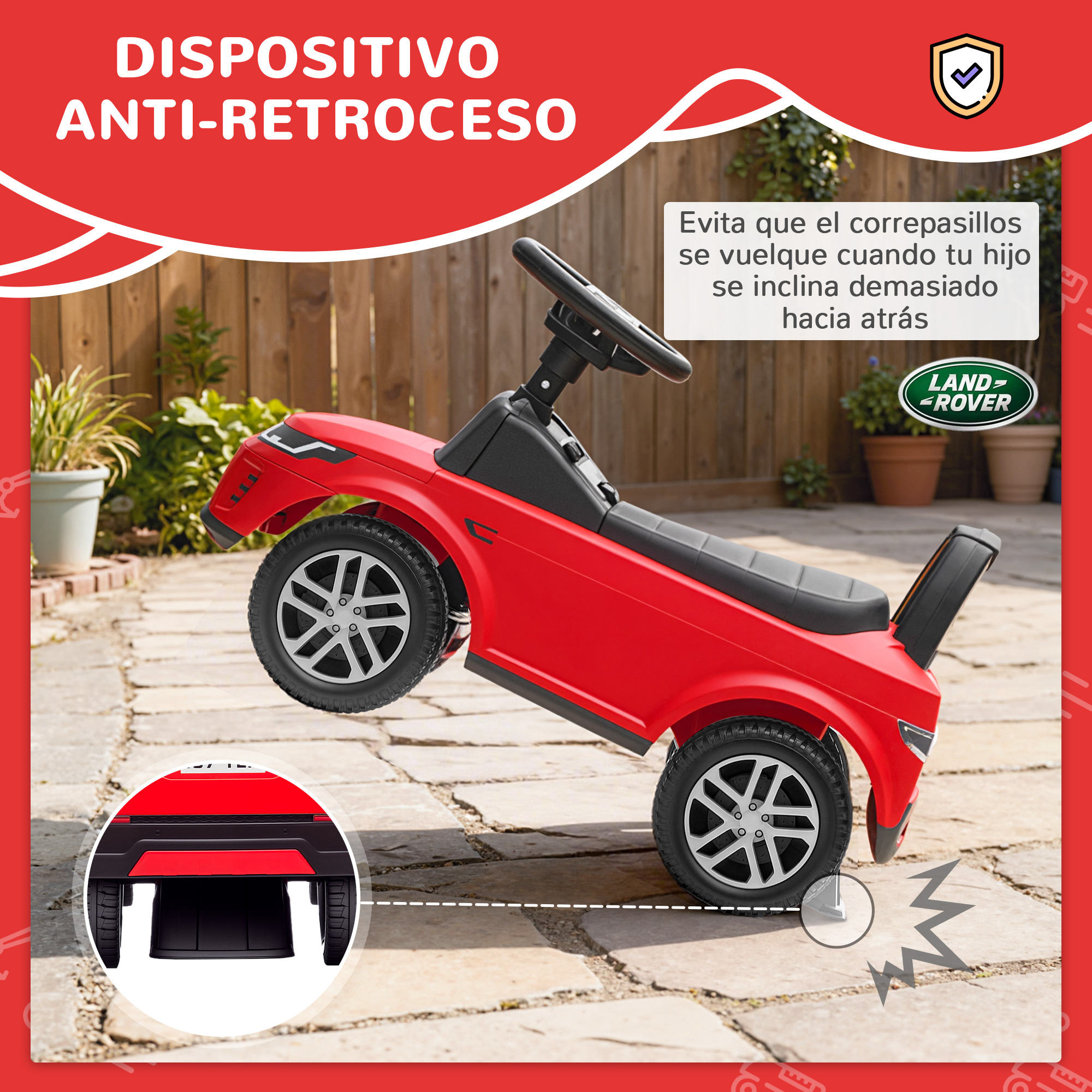 Un coche de juguete rojo con volante y logo Land Rover en un patio.