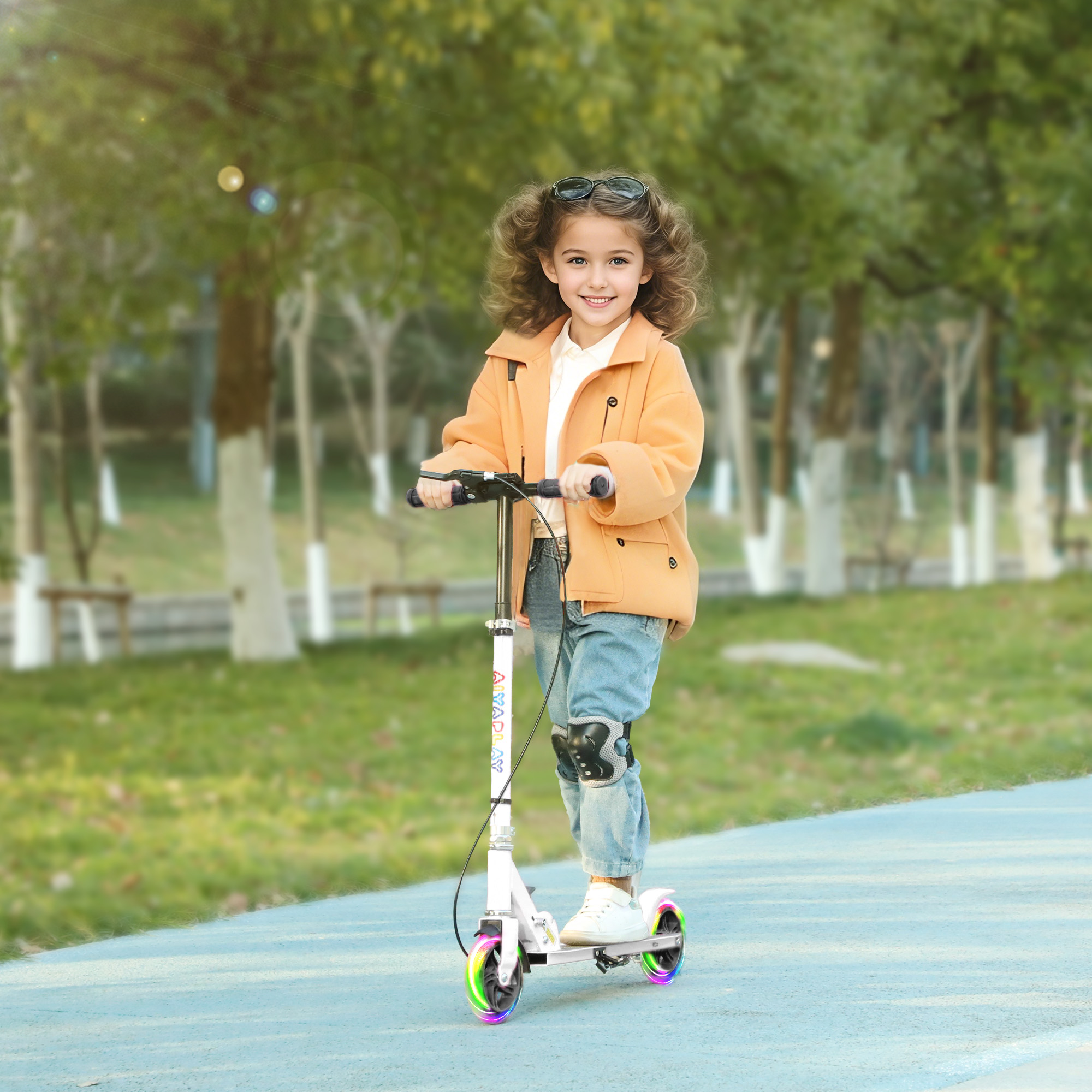 Una niña con abrigo naranja monta un patinete con ruedas luminosas en un parque.