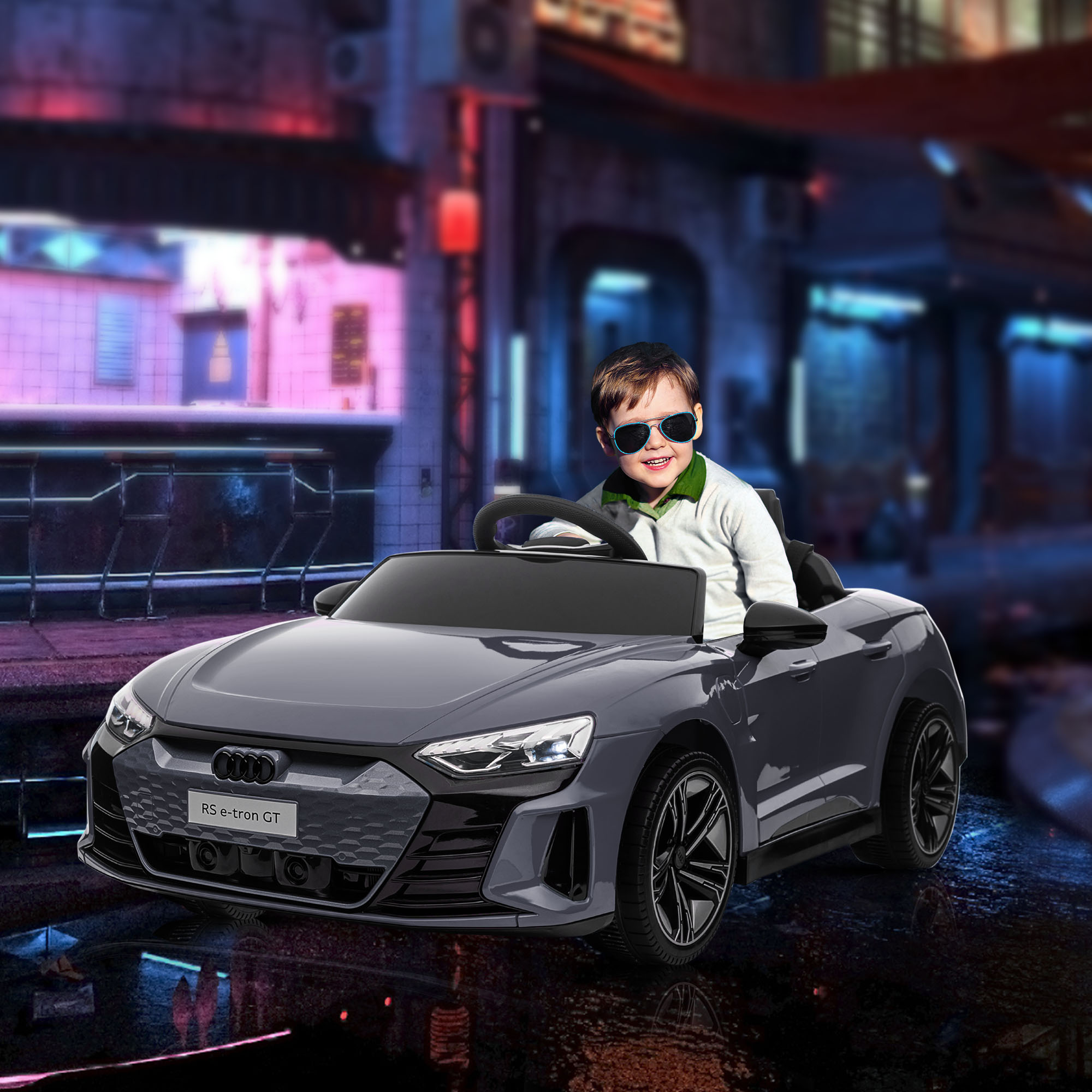 Un niño con gafas de sol conduce un coche eléctrico gris en una ciudad nocturna.