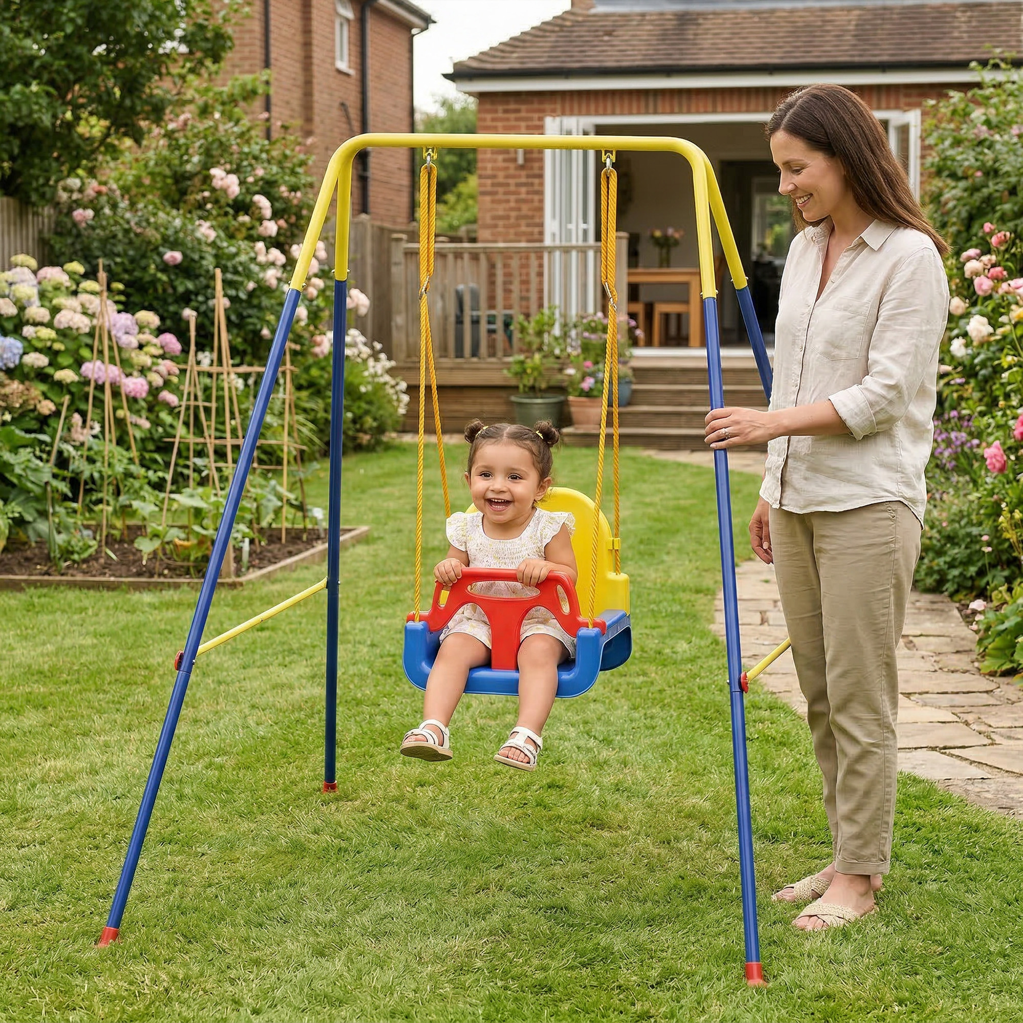 Una niña pequeña se columpia mientras una mujer está cerca en el jardín.