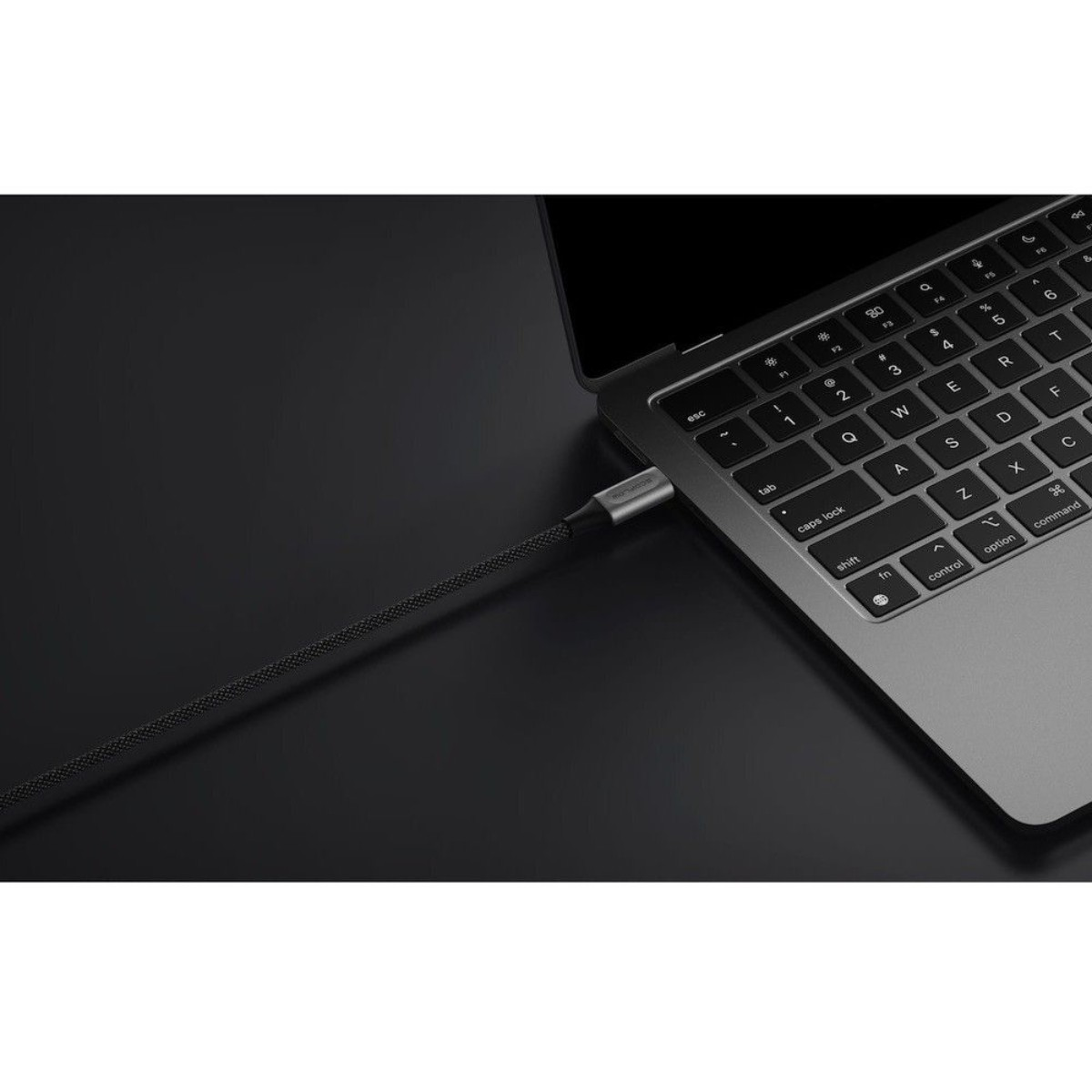 Un cavo di ricarica è collegato a un laptop, con focus sulla tastiera.