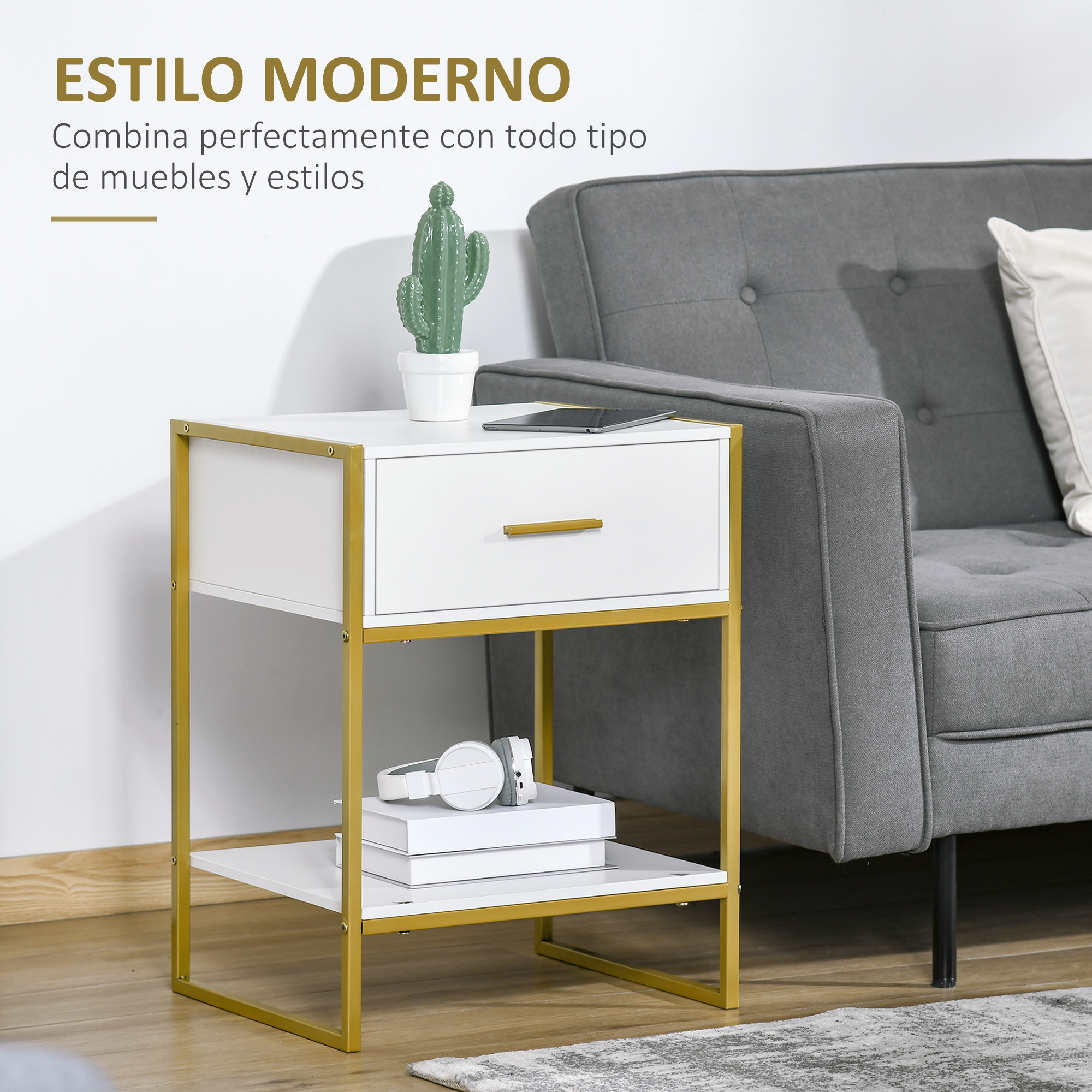 Mesita de noche blanca con marco dorado junto a sofá gris. Tiene cactus, teléfono y audífonos.
