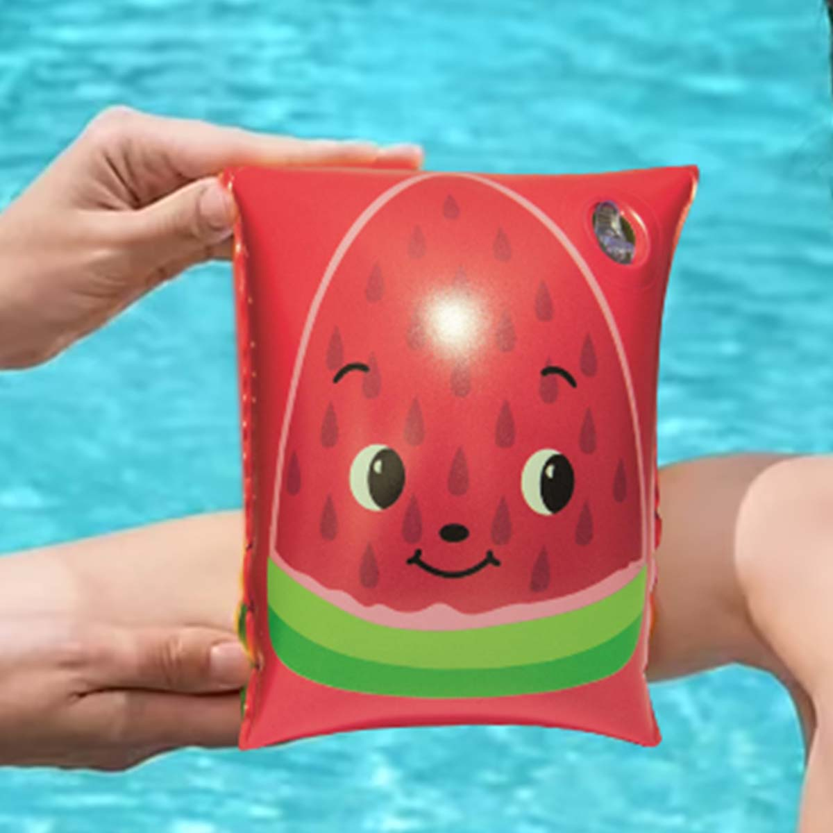 Bracciolo rosso con disegno anguria e viso stampato, vicino a una piscina.