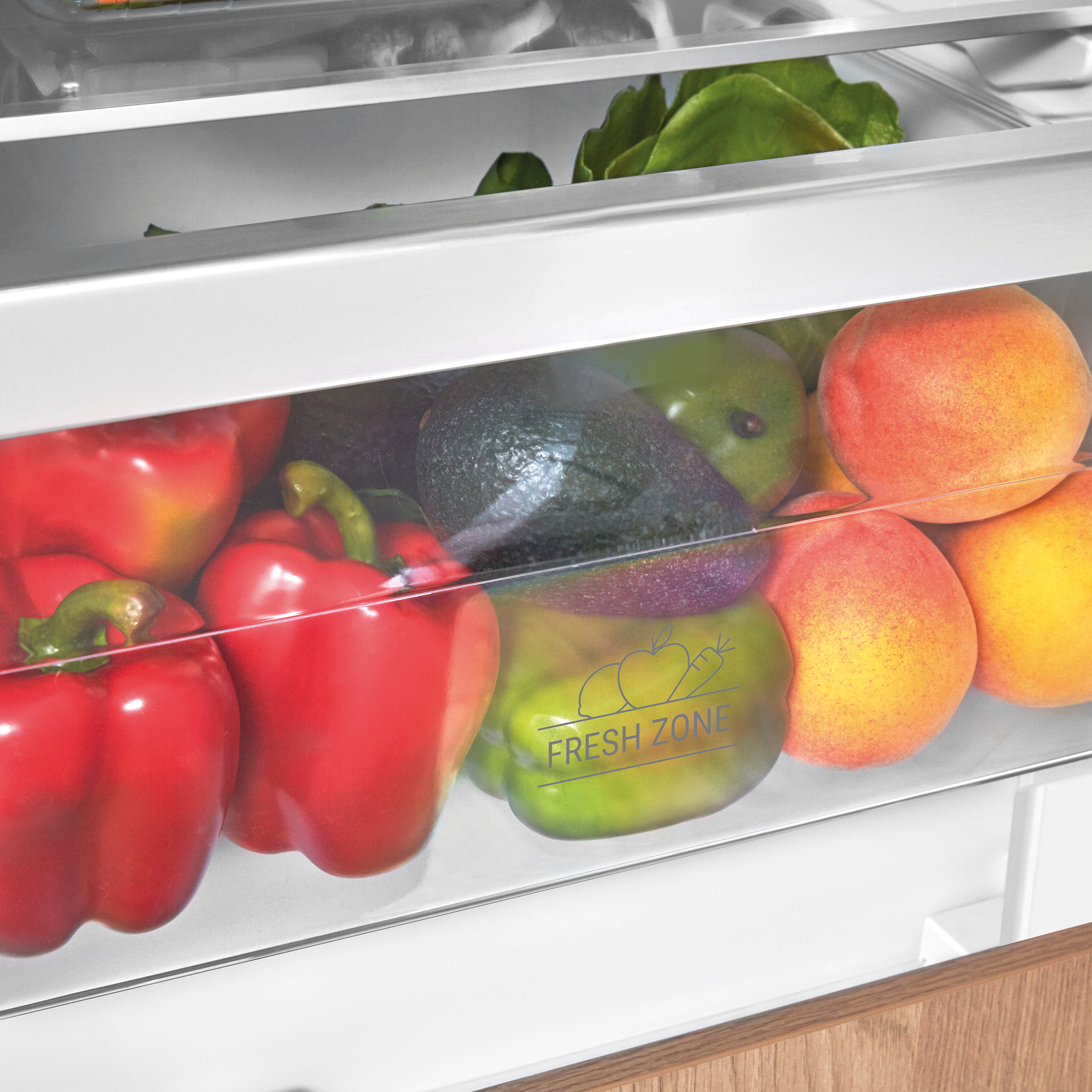 Rote Paprika, Avocados und Pfirsiche in einer Kühlschublade mit der Aufschrift „Fresh Zone“.