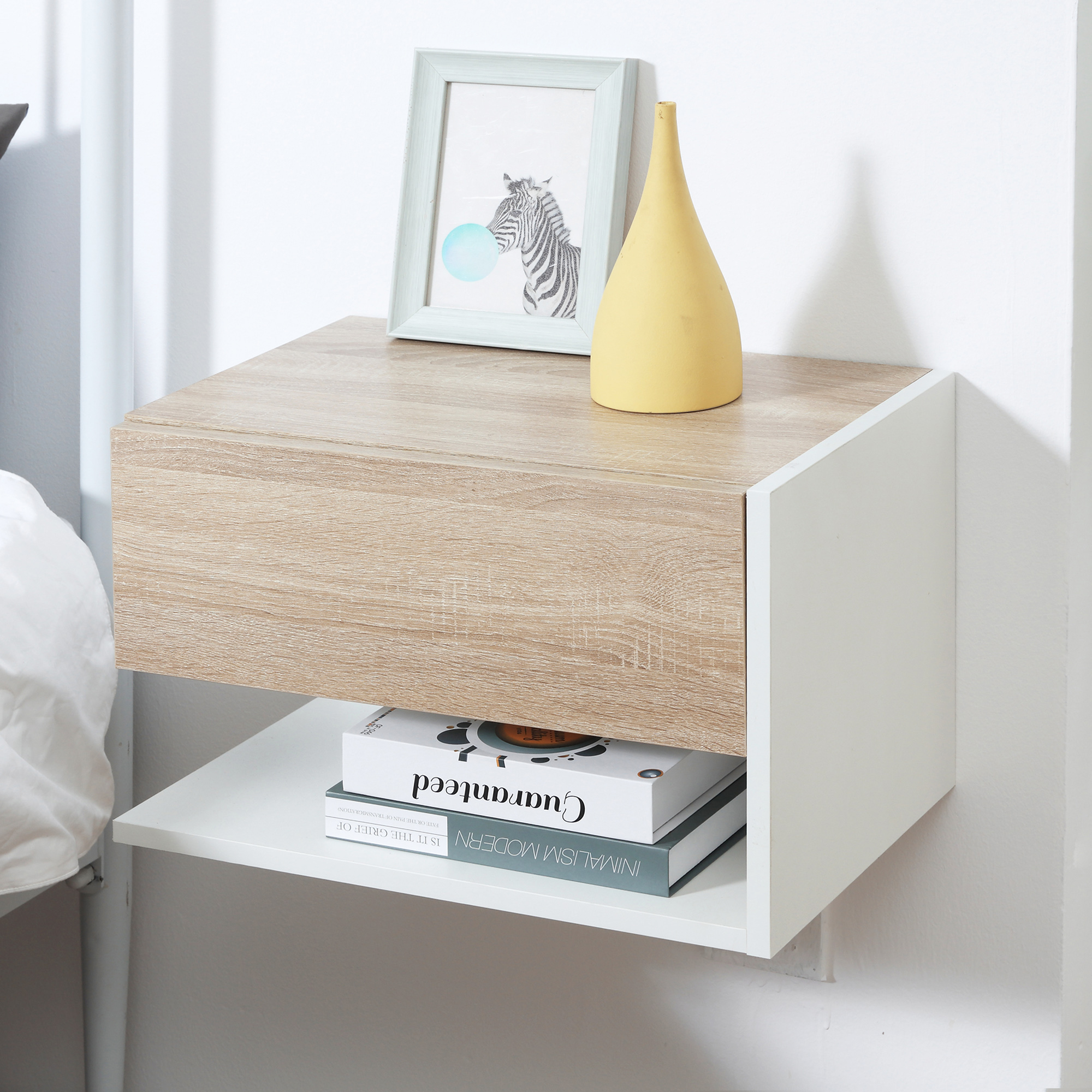 Un mueble cajón de madera con jarrón amarillo y arte de cebra enmarcado sobre libros.