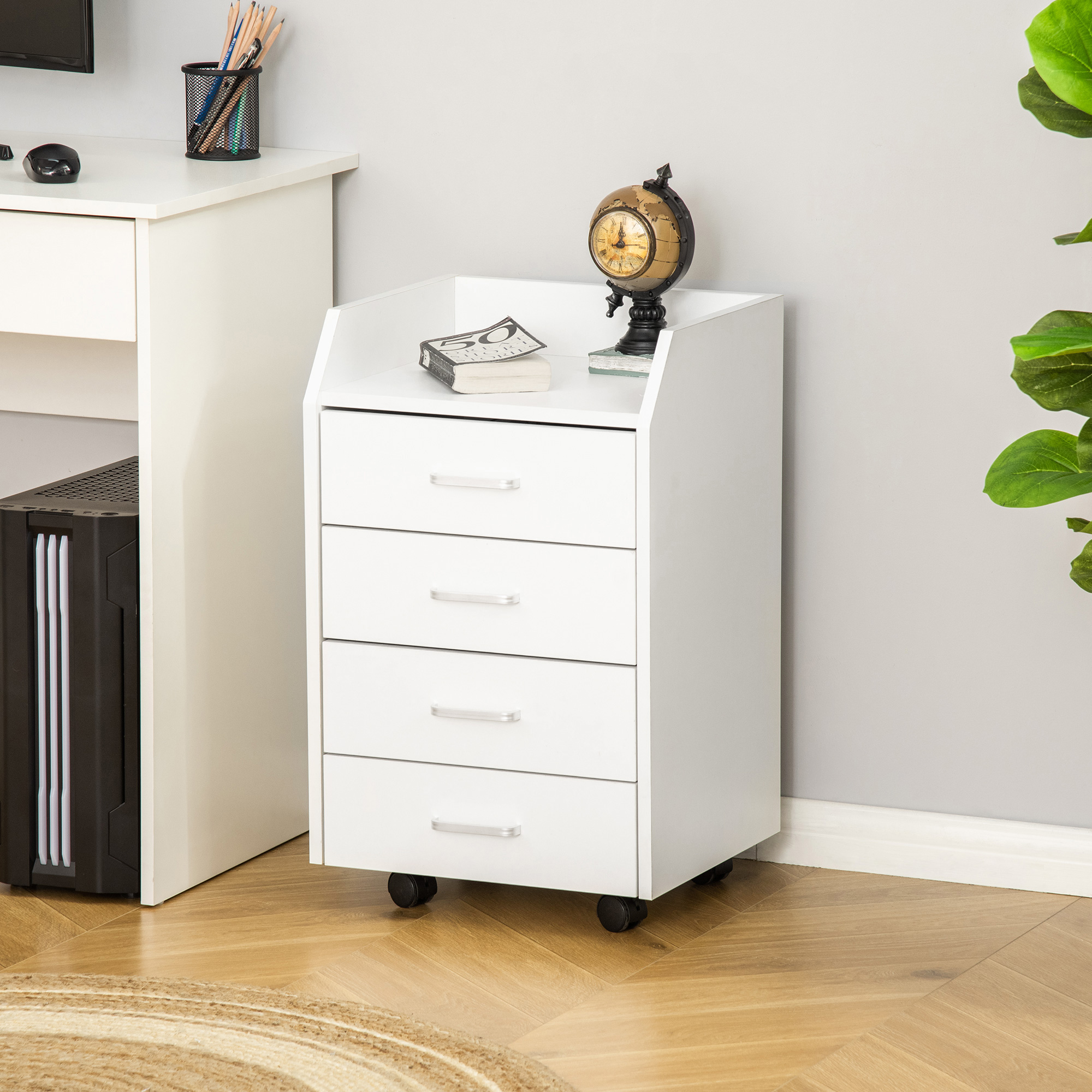 Un mueble blanco de cuatro cajones con ruedas, con un globo y libros encima.