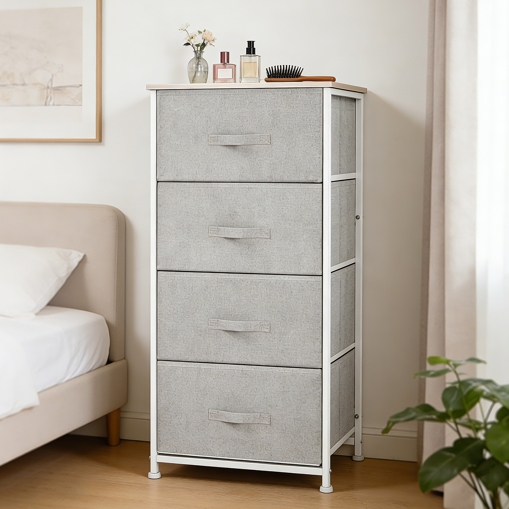 Cómoda de tela gris con cuatro cajones junto a una cama, decorada con jarrones y botellas.