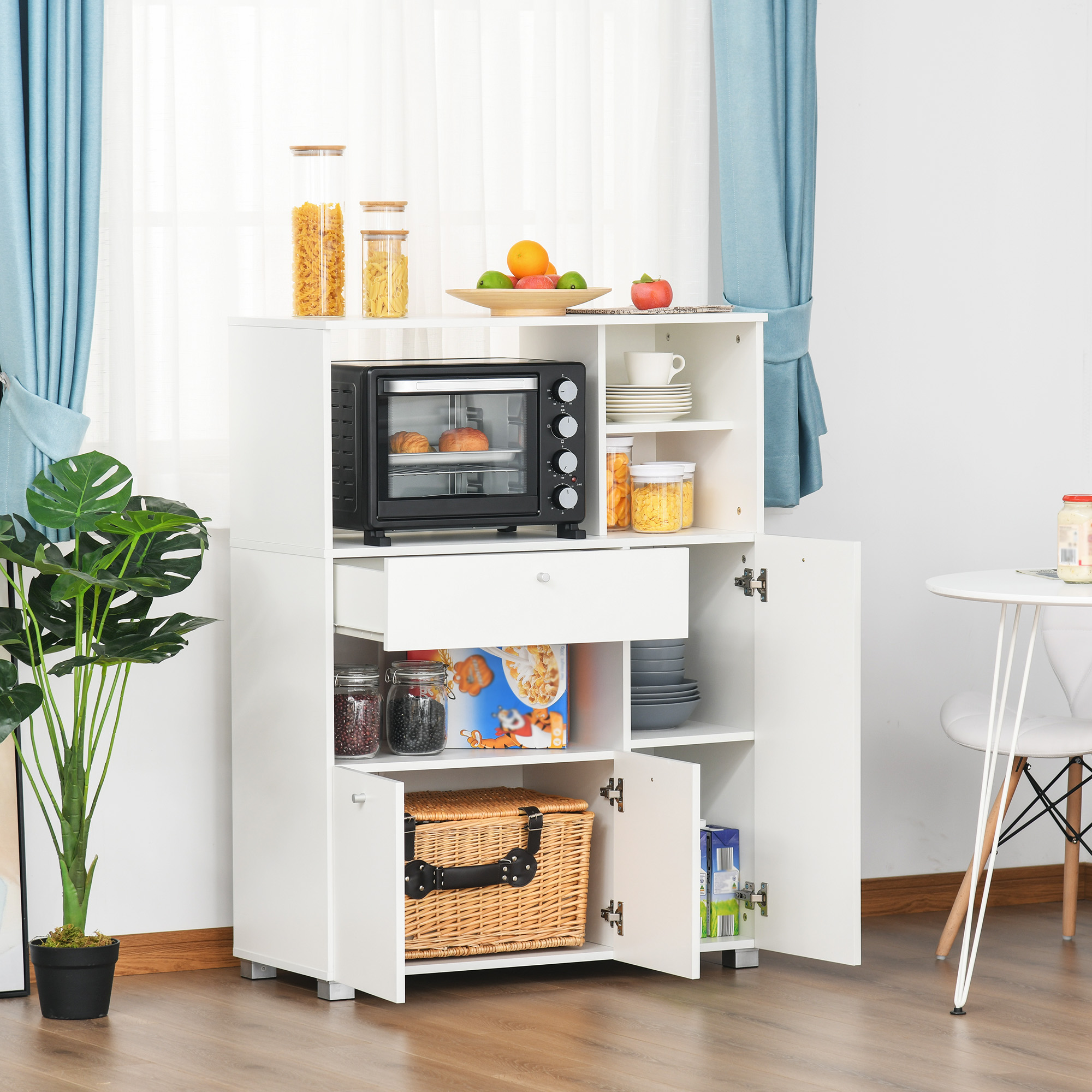 Un mueble de cocina blanco con horno, tarros de comida, cesta y platos.