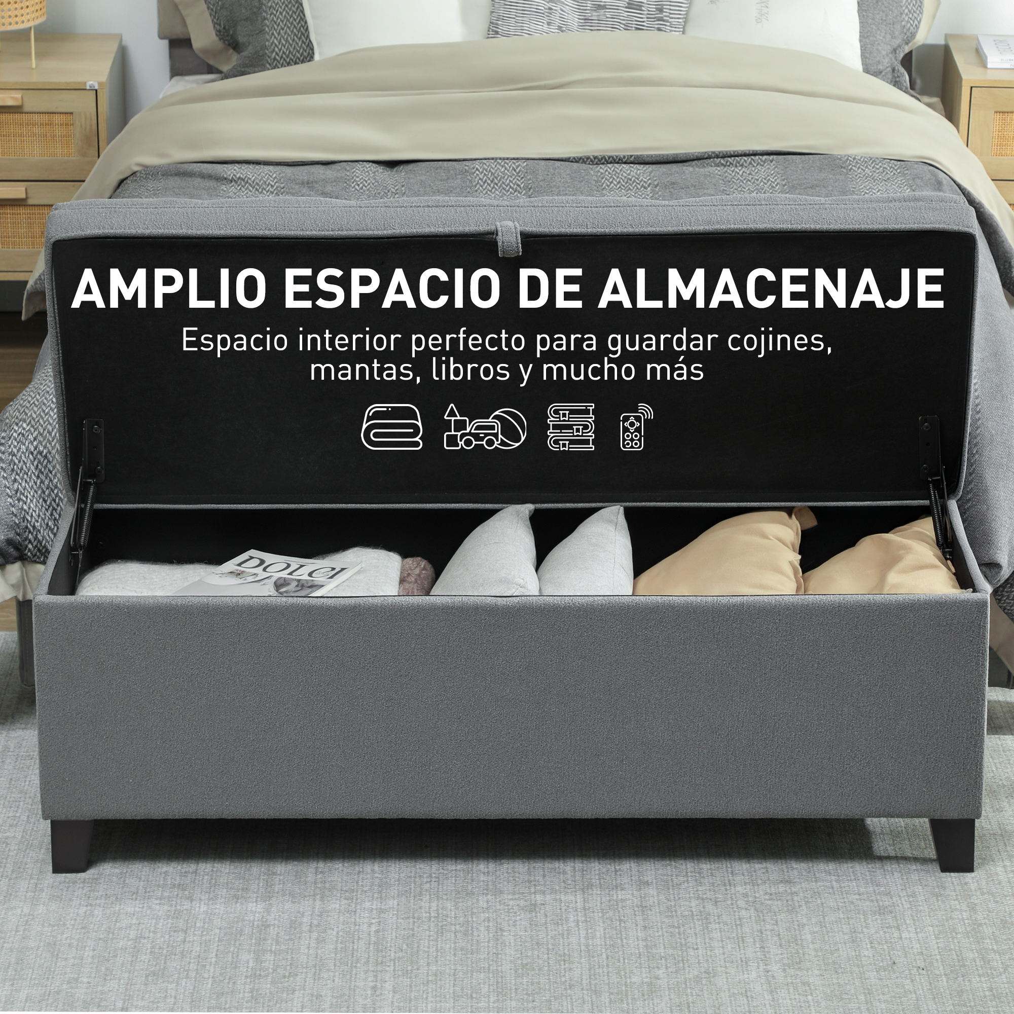 Arcón de almacenamiento gris con tapa abierta, lleno de cojines y mantas.