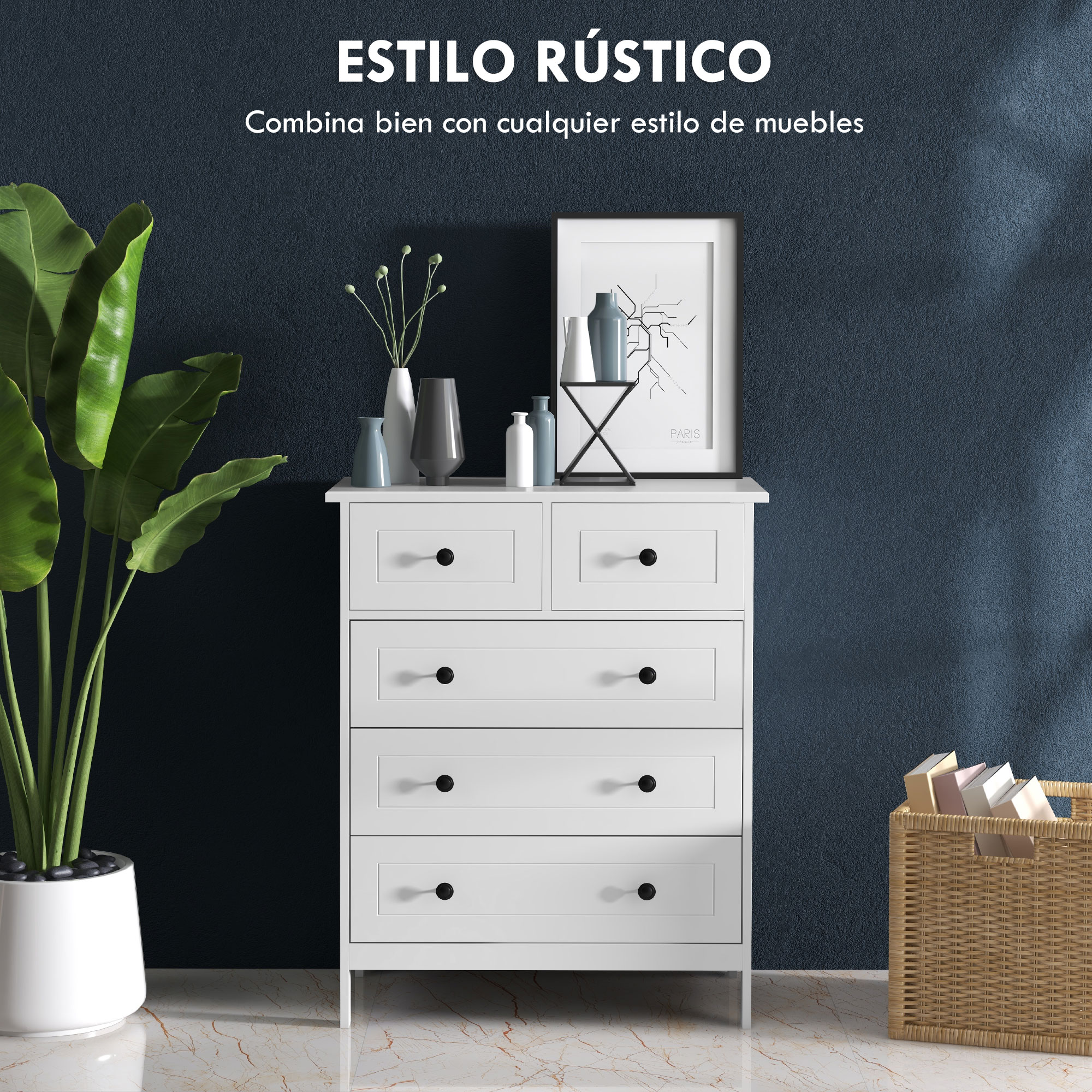 Cómoda blanca con tiradores negros, junto a una planta y una cesta con libros.