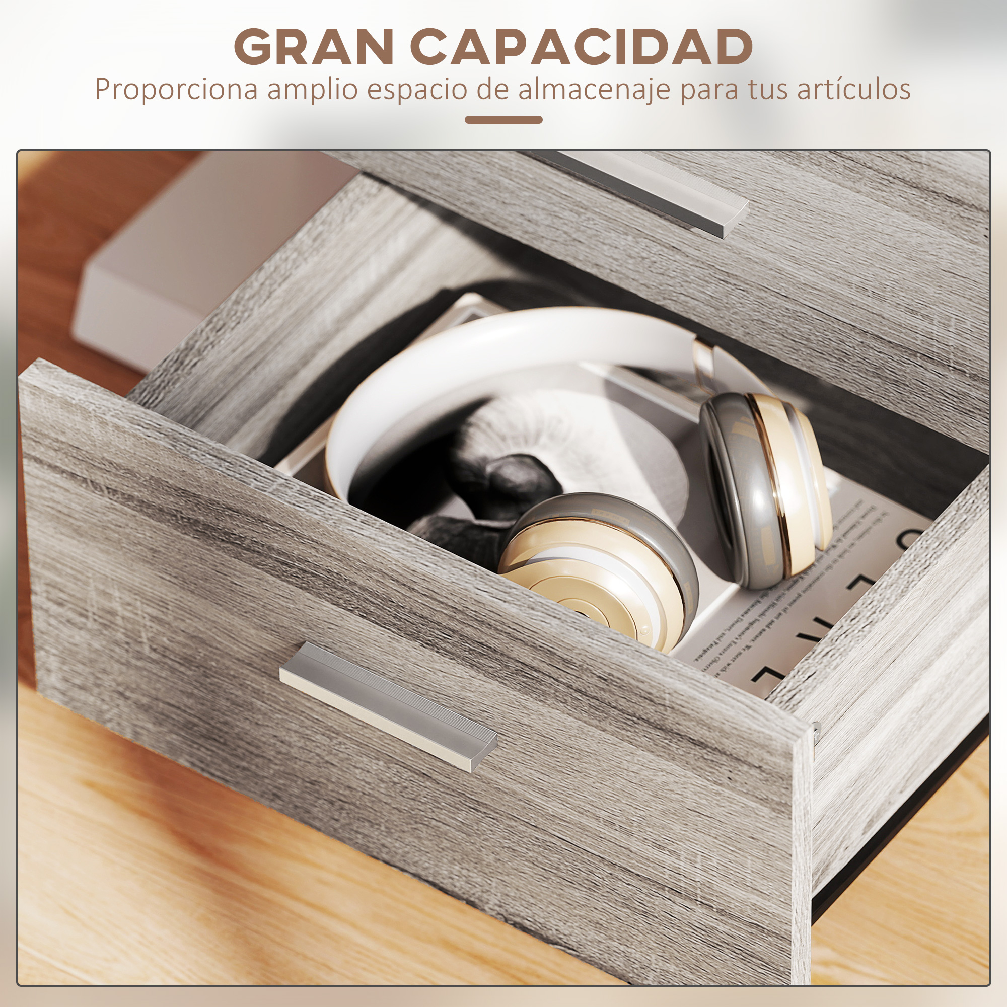 Un cajón abierto de armario con auriculares y libros dentro, sobre una mesa de madera.