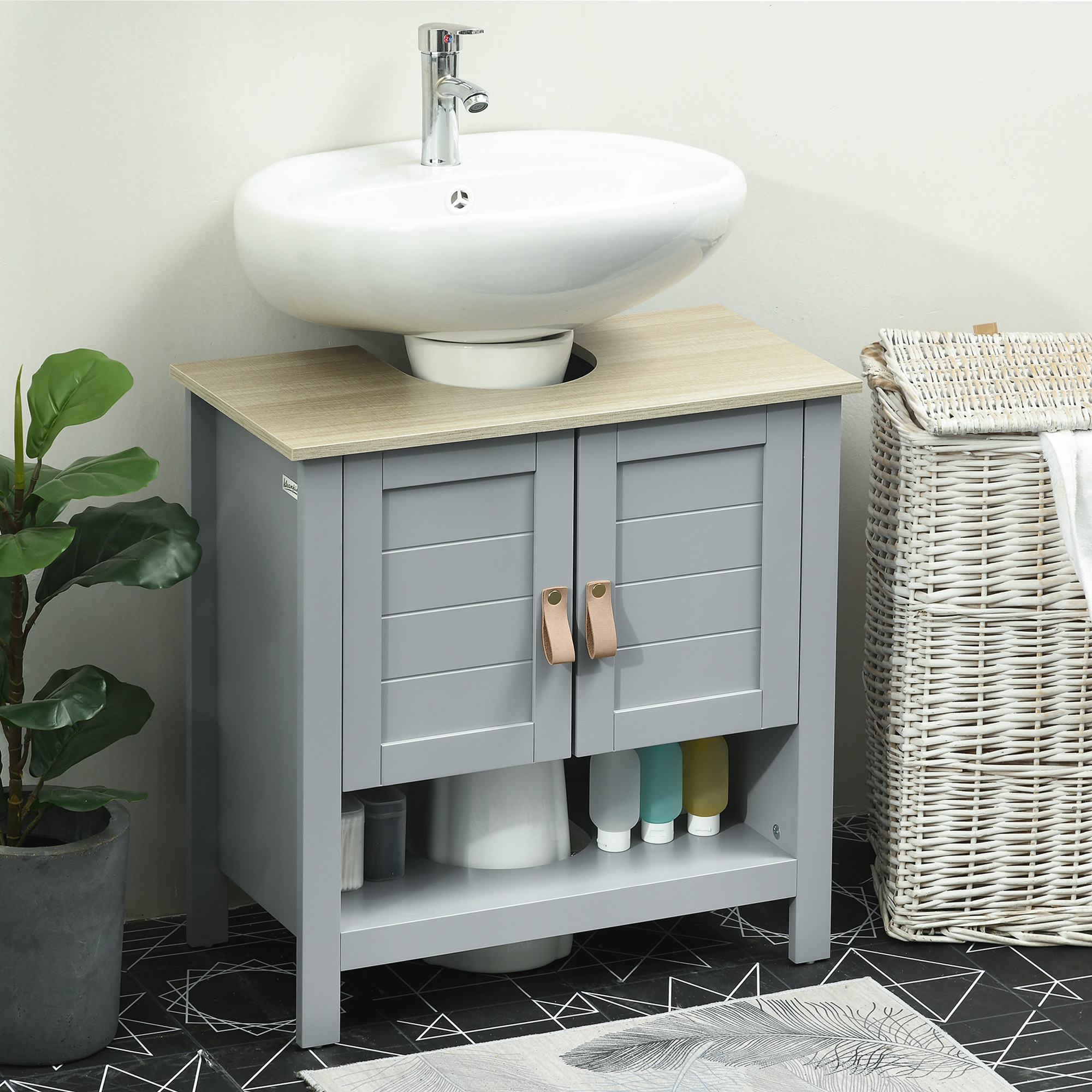 Mueble de baño gris con tapa de madera, lavabo blanco, grifo, planta y cesto.