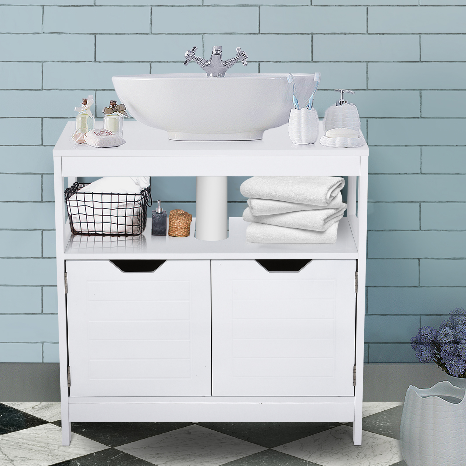 Un mueble de baño blanco con lavabo, toallas y accesorios frente a paredes alicatadas de azul.