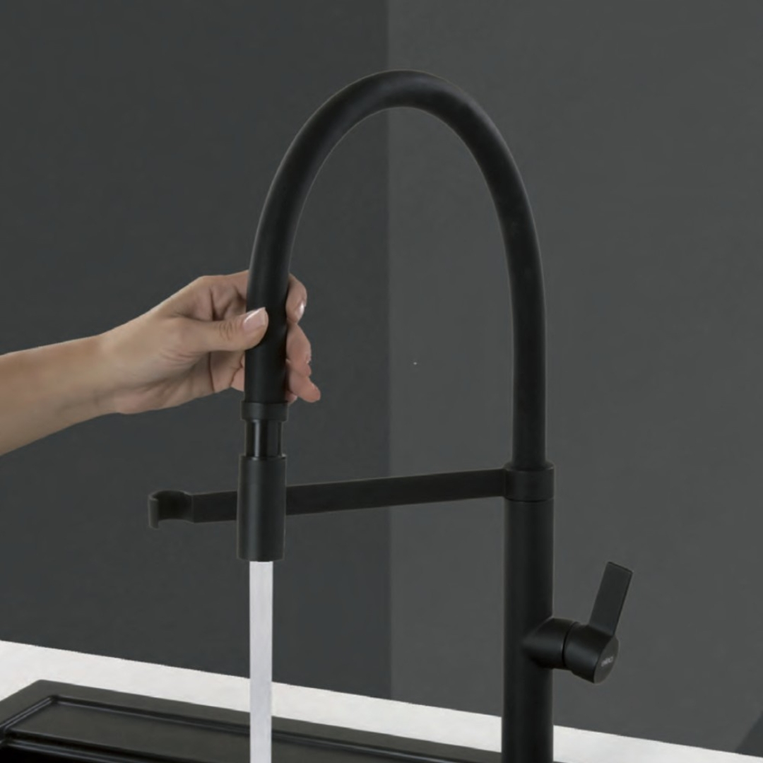 Una mano estrae un rubinetto nero; l'acqua scorre verso il basso.