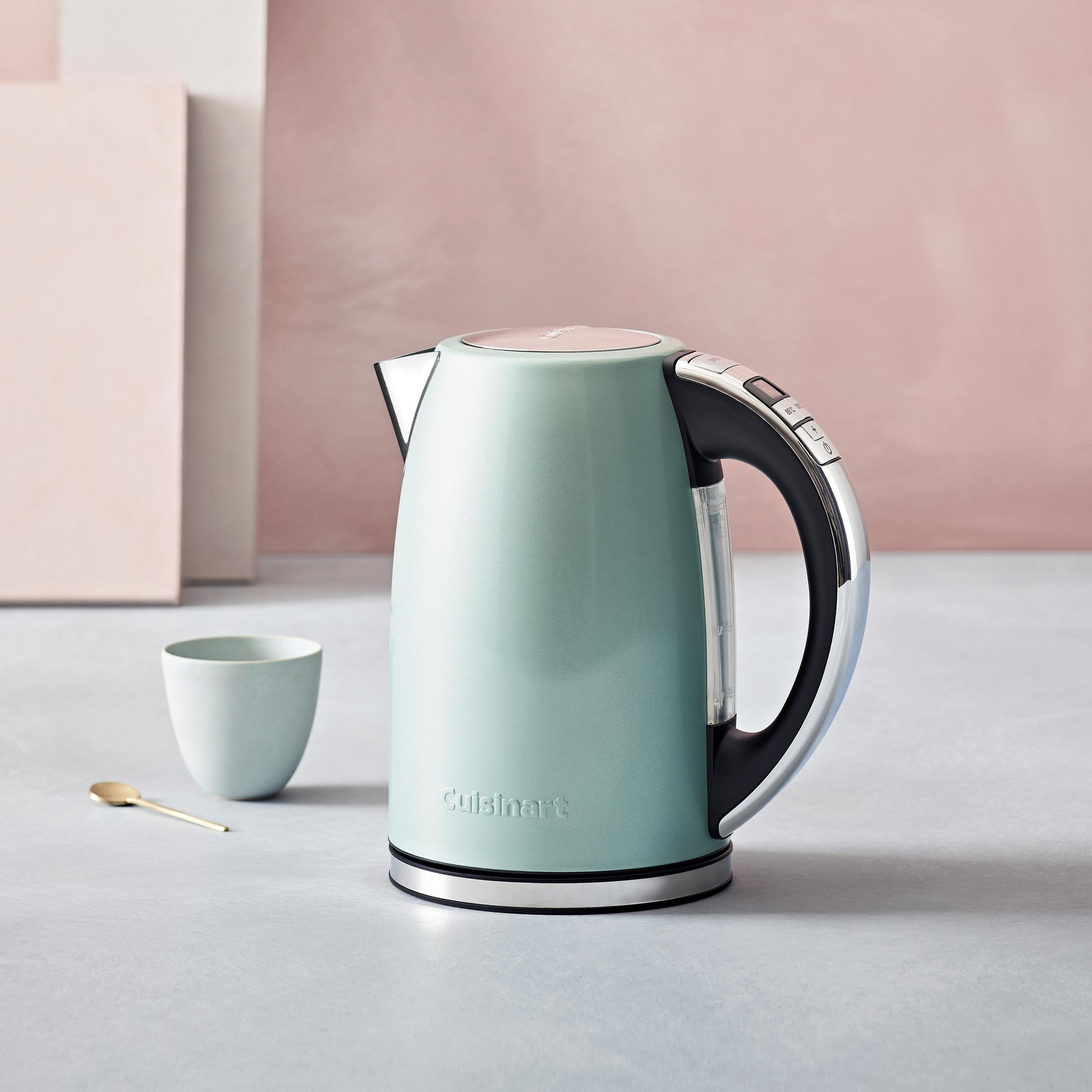 Un bollitore elettrico verde menta con accenti cromati e una tazza.