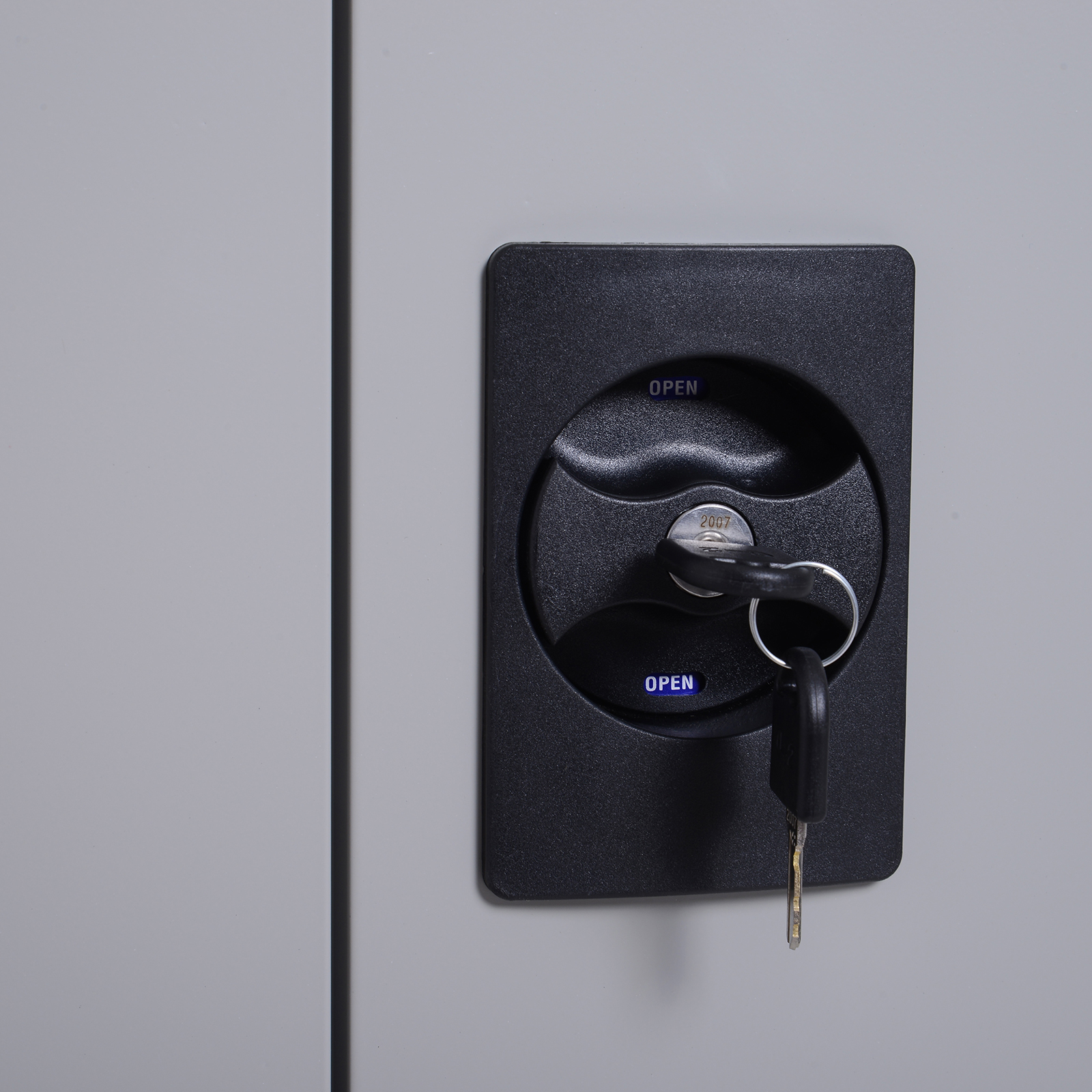Mecanismo de cerradura negro con dos llaves, etiquetado "OPEN".