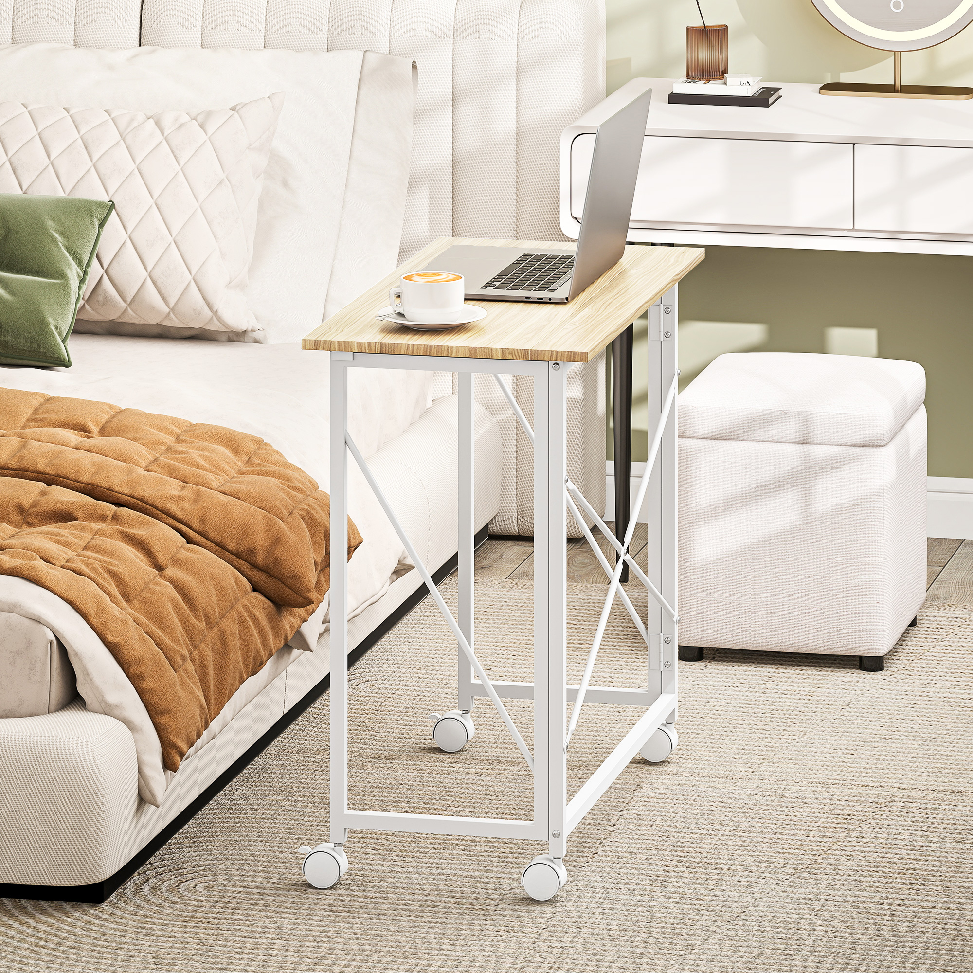 Un portátil y una taza de café descansan sobre una mesa auxiliar de madera con estructura de metal blanco.