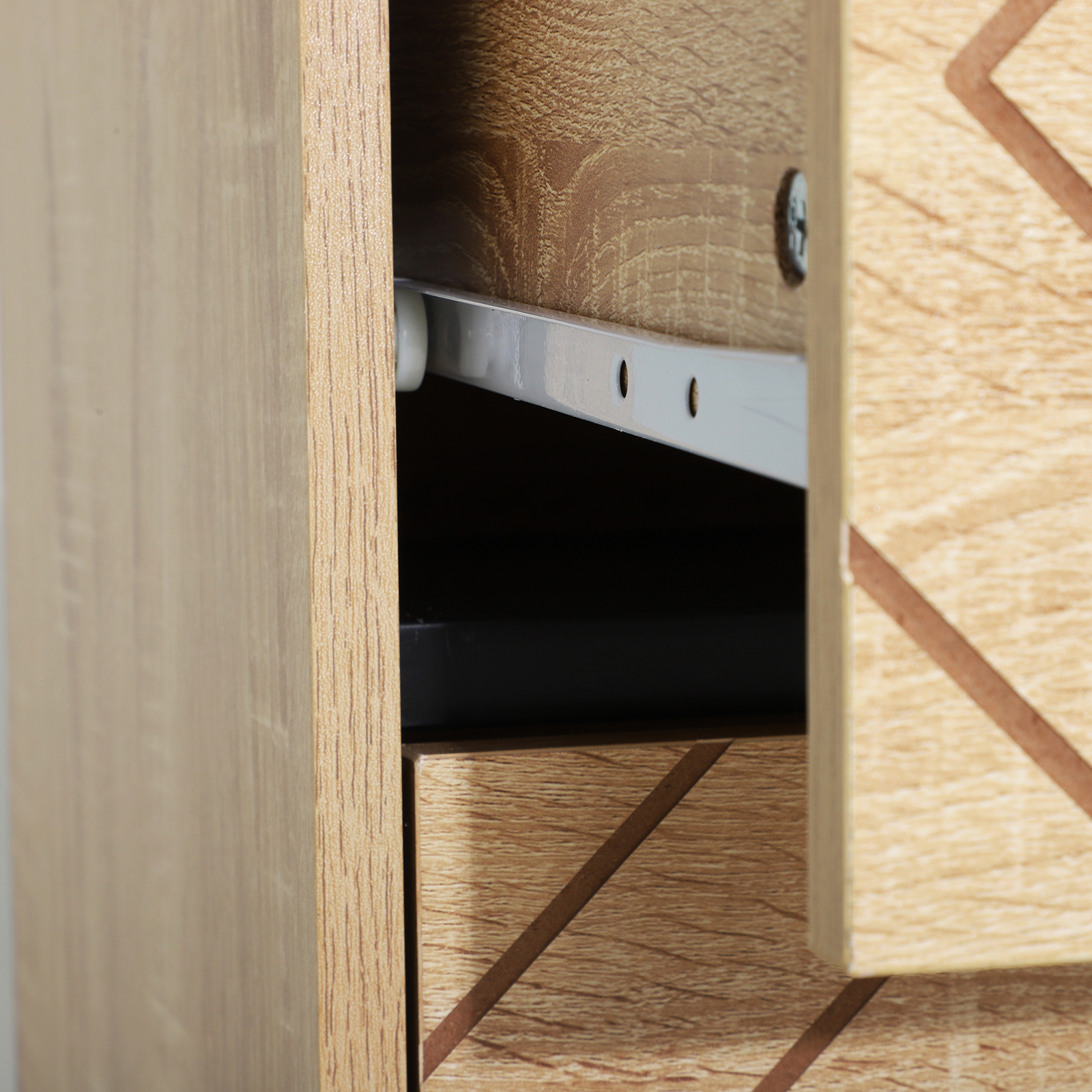 Primer plano de un cajón de cómoda de madera, guía y rueda.