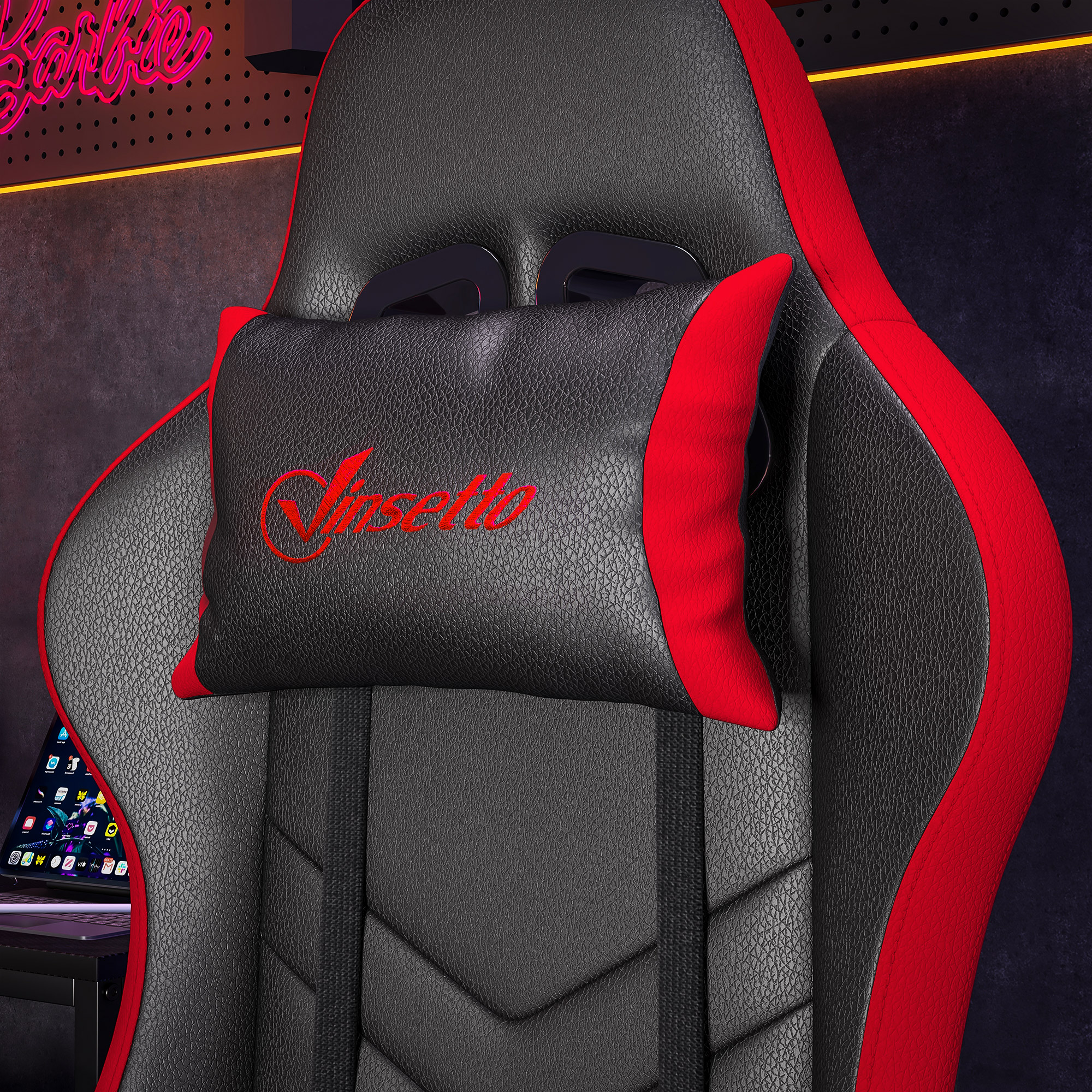 Silla gaming negra con detalles rojos y cojín cervical con logo rojo.