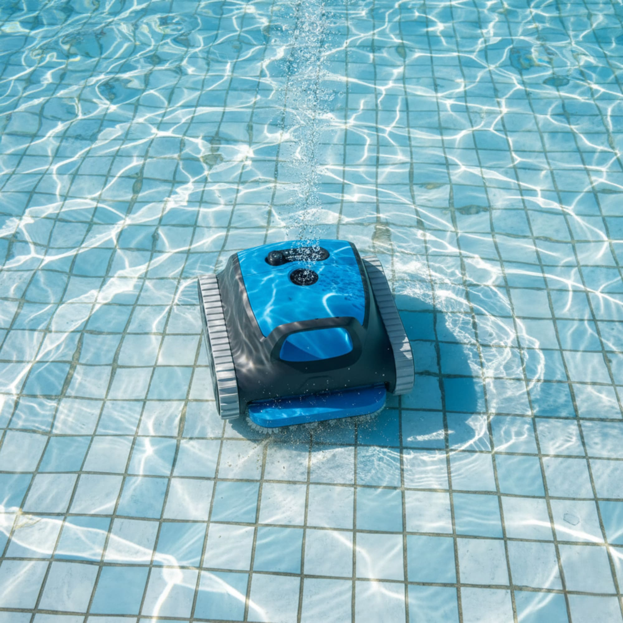 Un robot limpiafondos azul con ruedas limpia el fondo de azulejos de la piscina, creando burbujas.