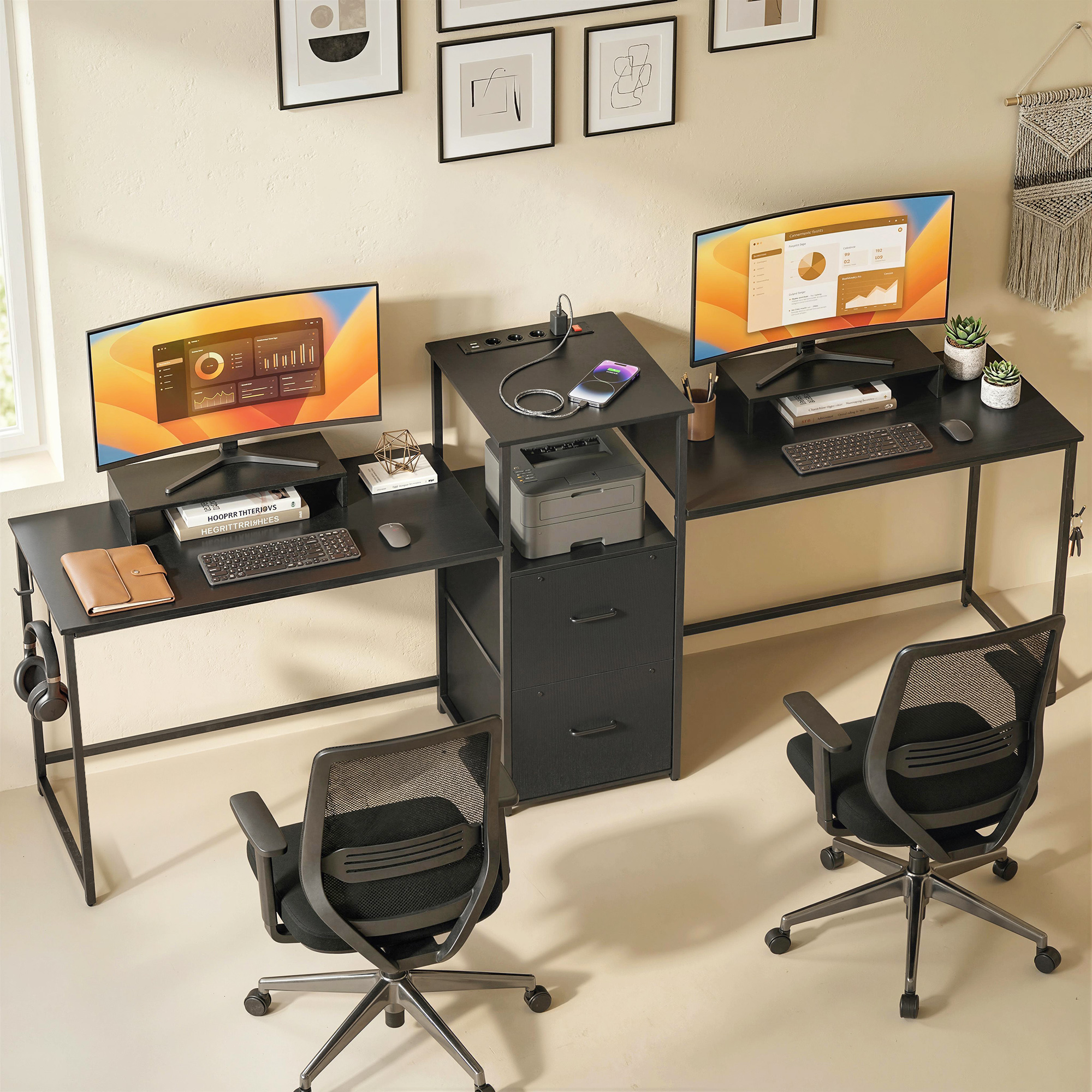 Dos escritorios negros con monitores, computadoras, impresoras y sillas de oficina.