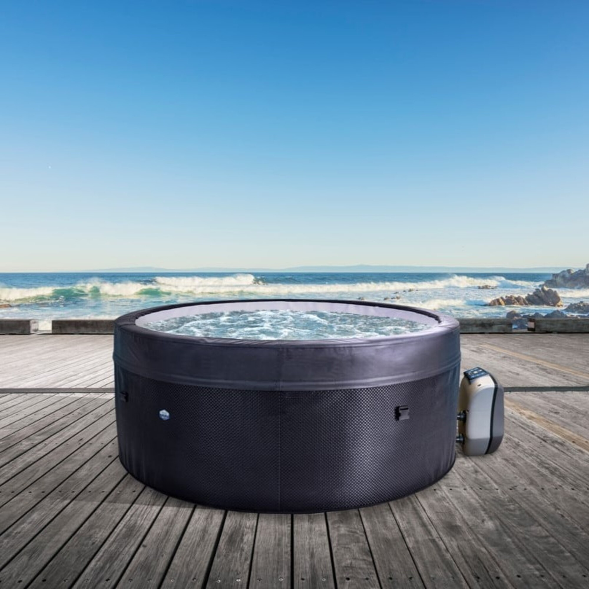 Un jacuzzi inflable con agua burbujeante se encuentra en una terraza de madera junto al mar.