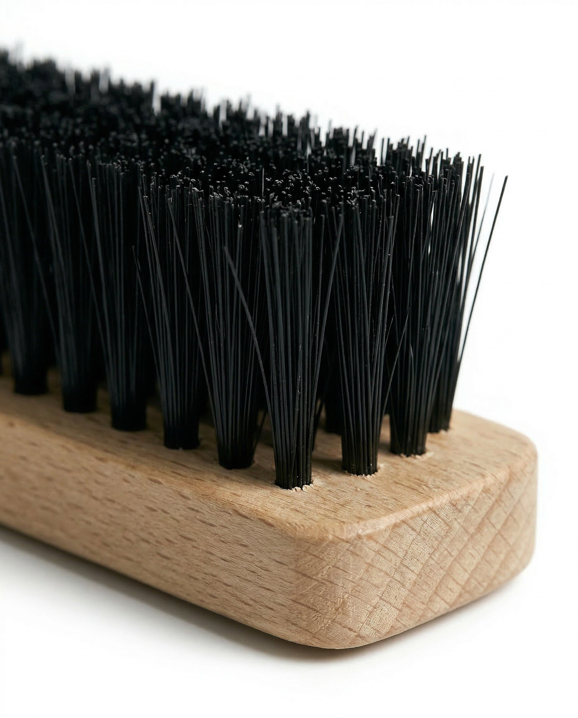 Een houten borstelkop met zwarte borstels tegen een witte achtergrond.
