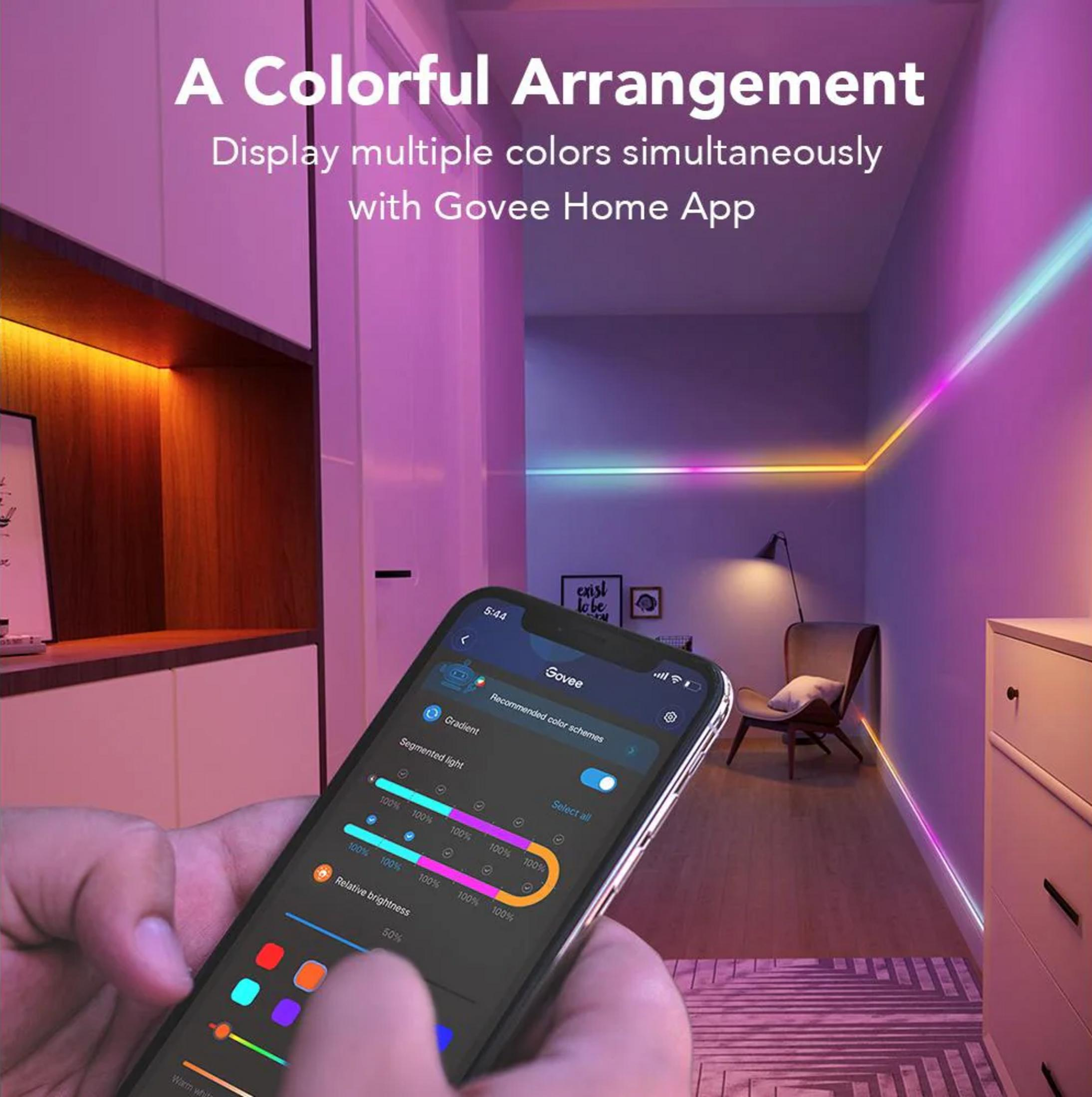 Uno smartphone controlla strisce LED colorate in un corridoio con mobili e arte.