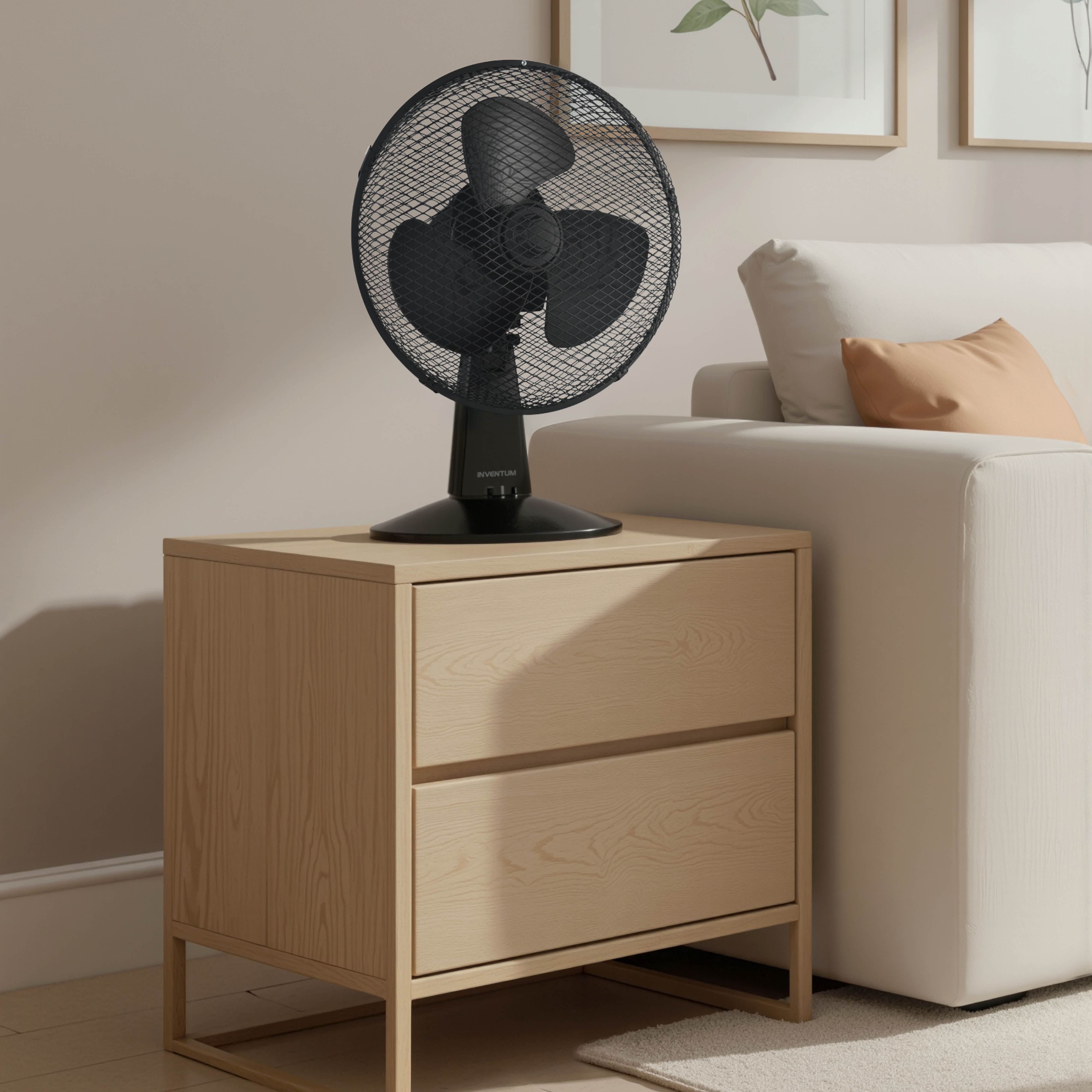 Een zwarte tafelventilator staat op een licht houten nachtkastje naast een bank.