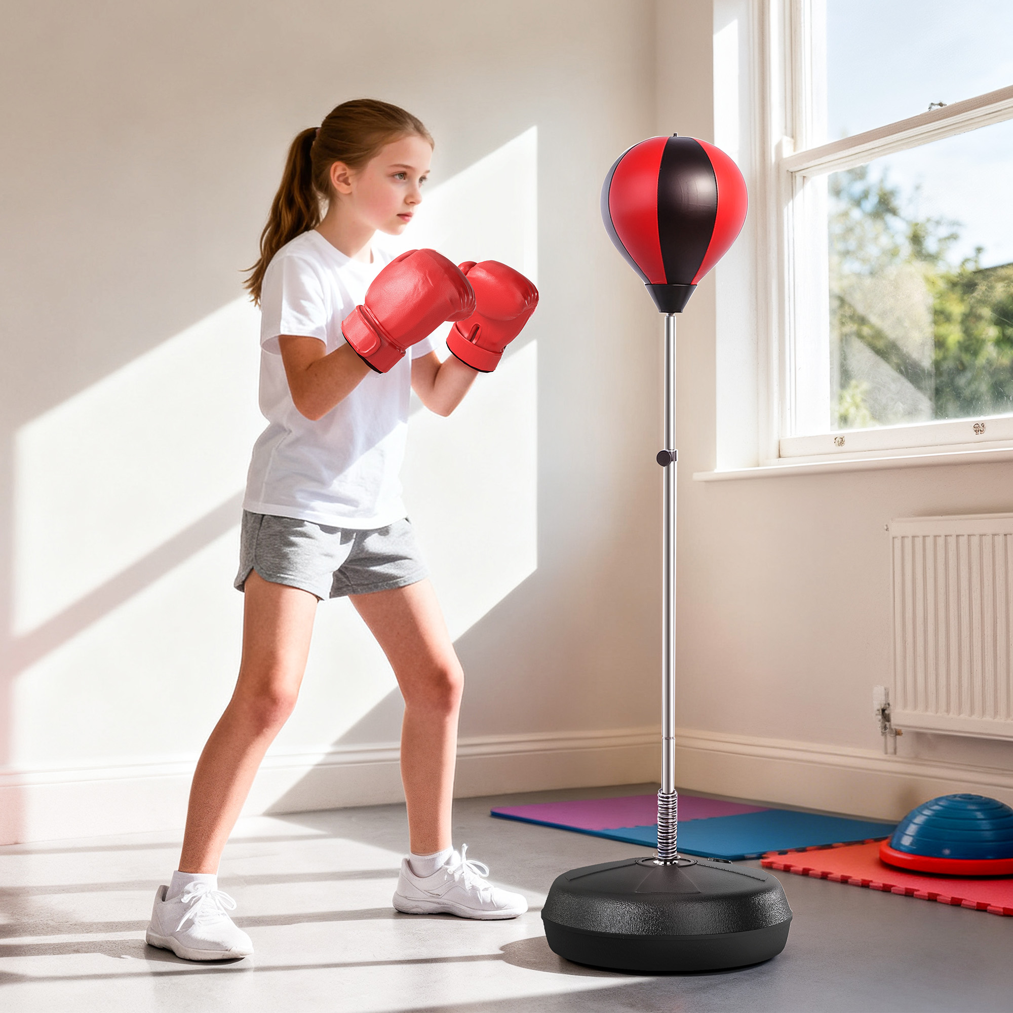 Una niña con guantes de boxeo rojos practica con un saco de boxeo.