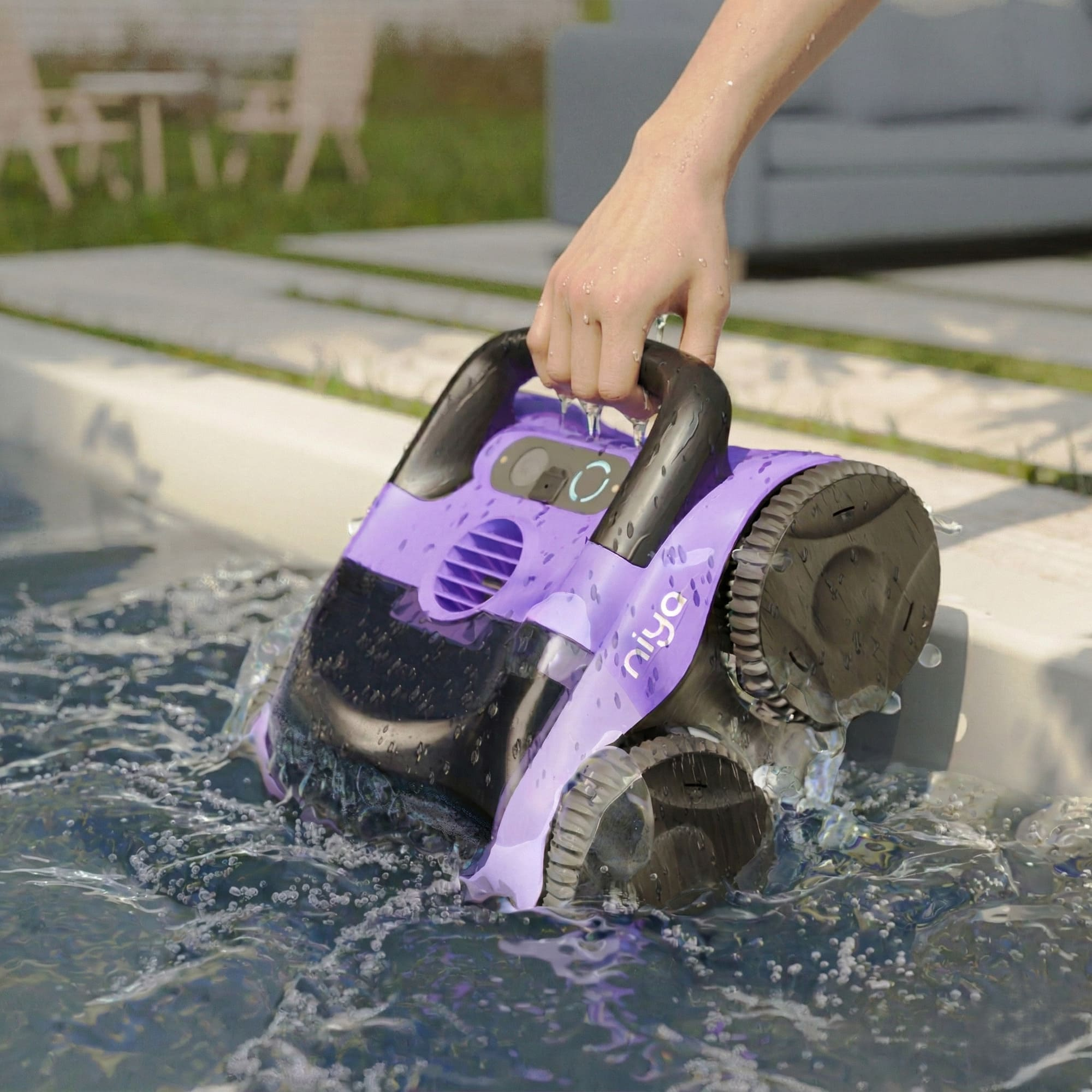 Una mano saca un limpiador de piscina morado del agua.