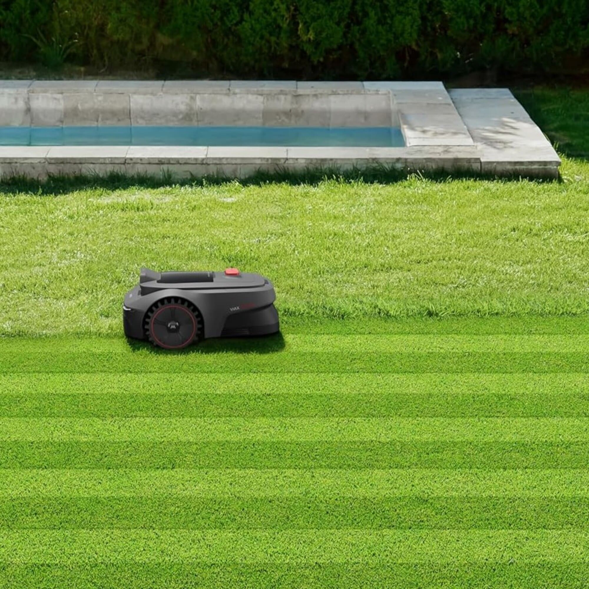 Un robot cortacésped negro corta un césped perfectamente recortado junto a una piscina.