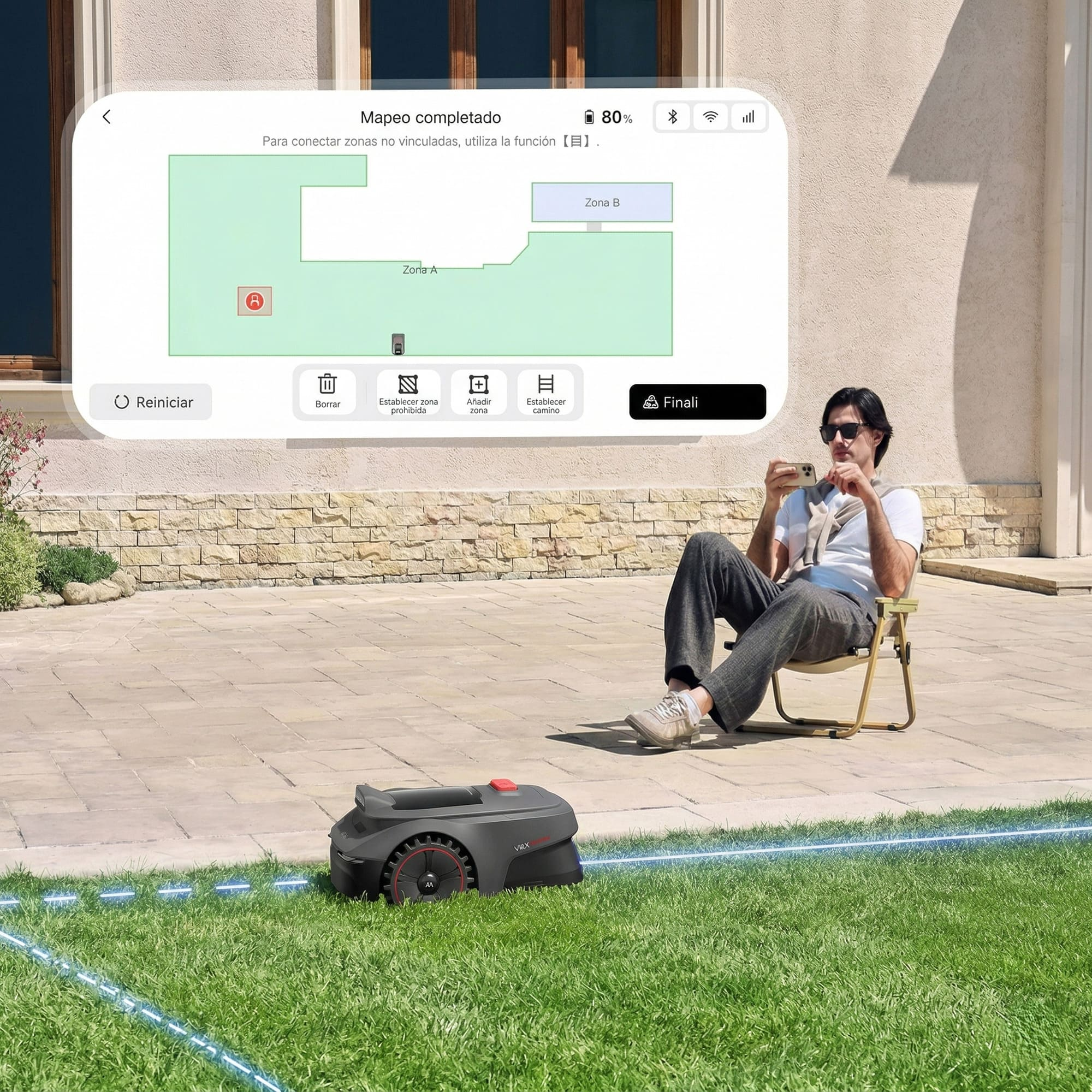 Un hombre sentado en el jardín mirando su teléfono, con un robot cortacésped cerca.